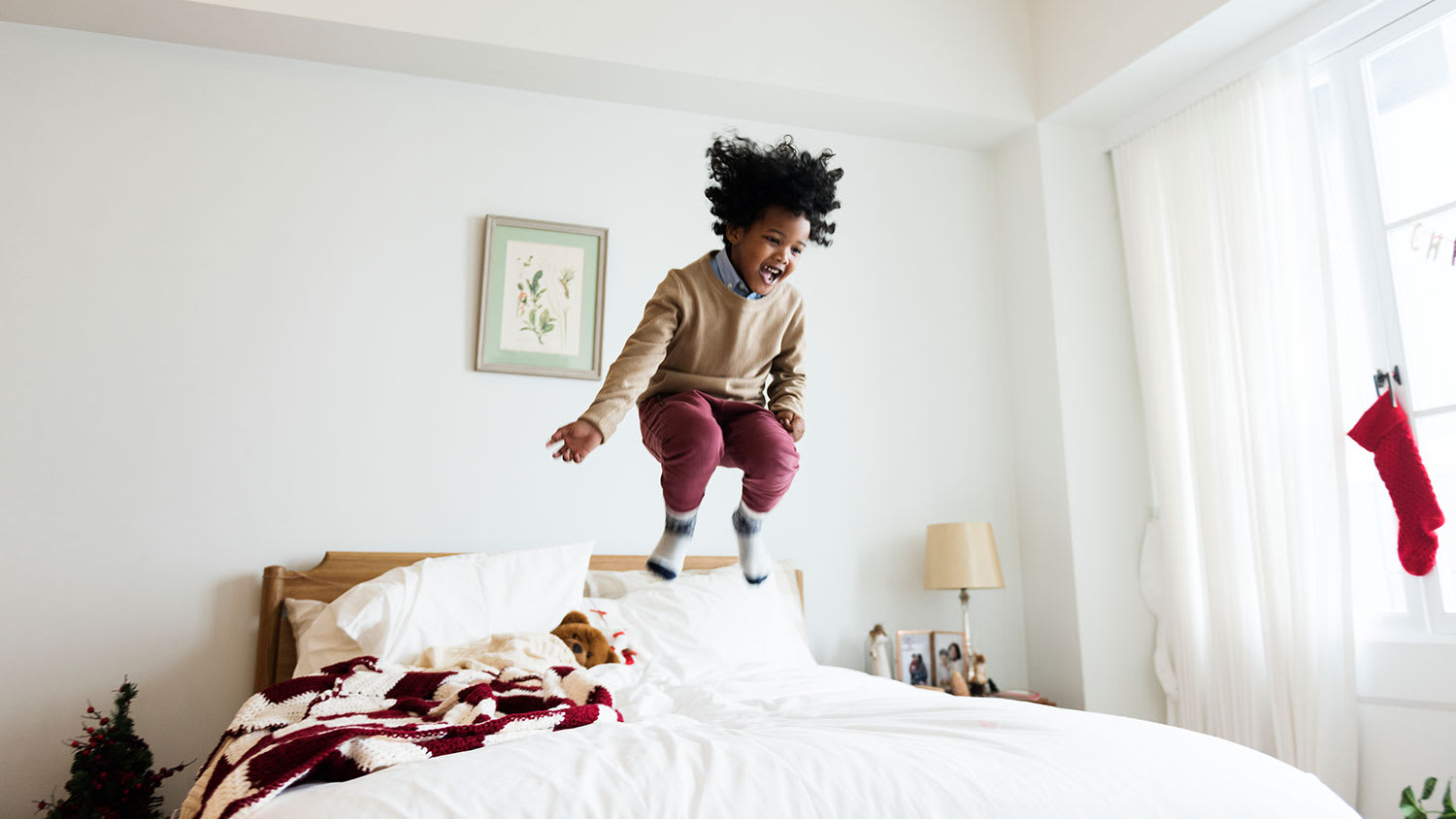 Boy having fun jumping on bed