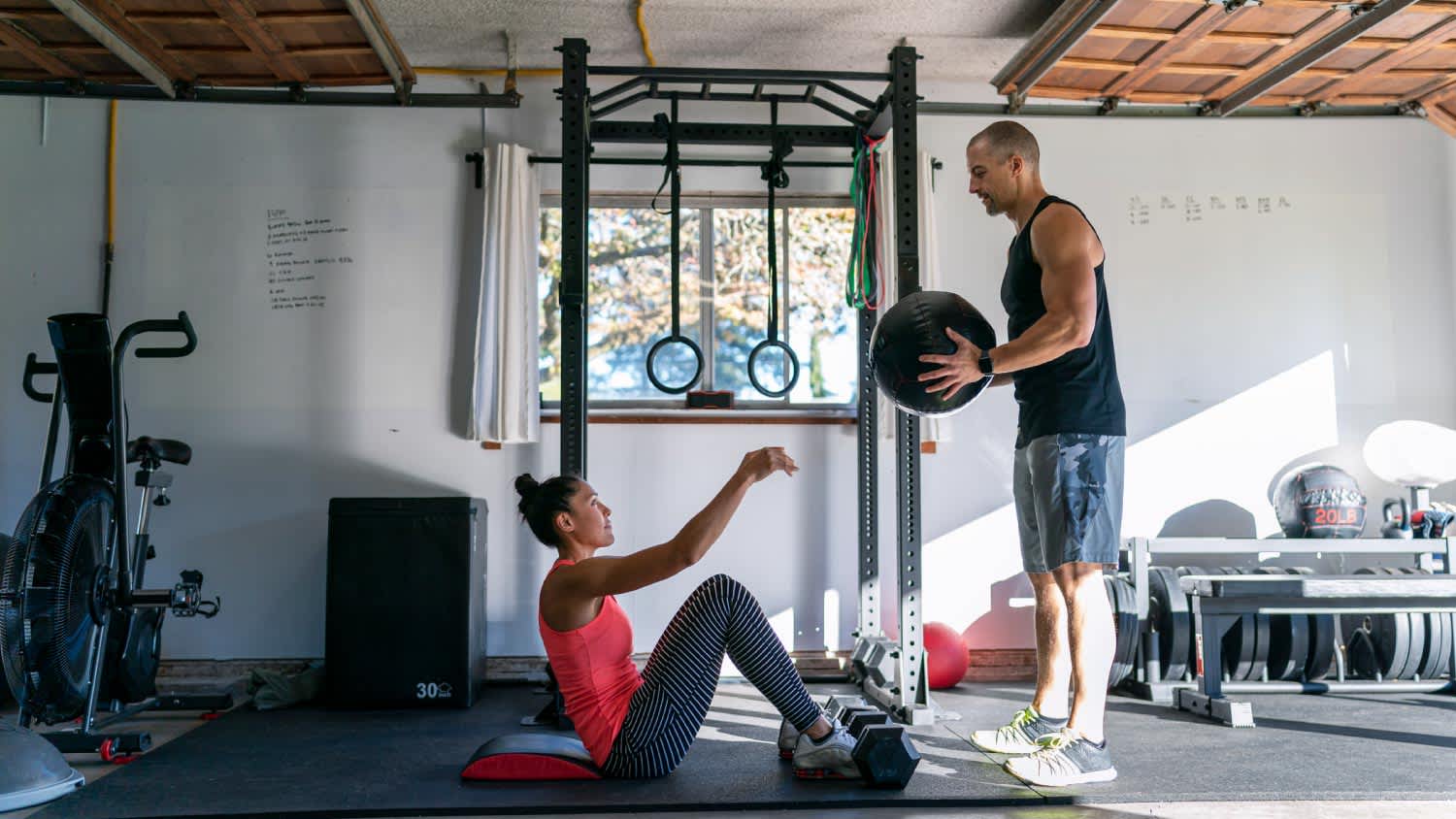 A woman exercising with personal trainer in home gym