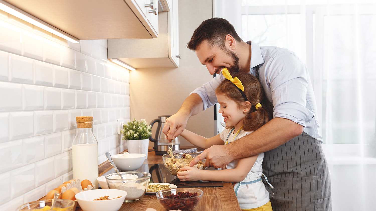 father and daughter cooking in kitchen