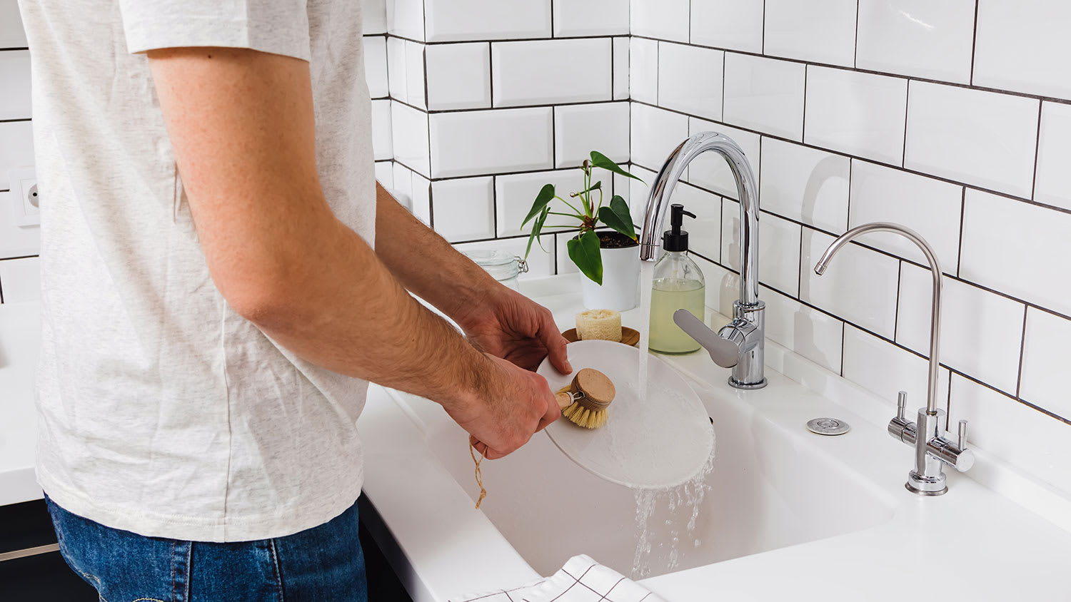 Man washing dishes with a brush