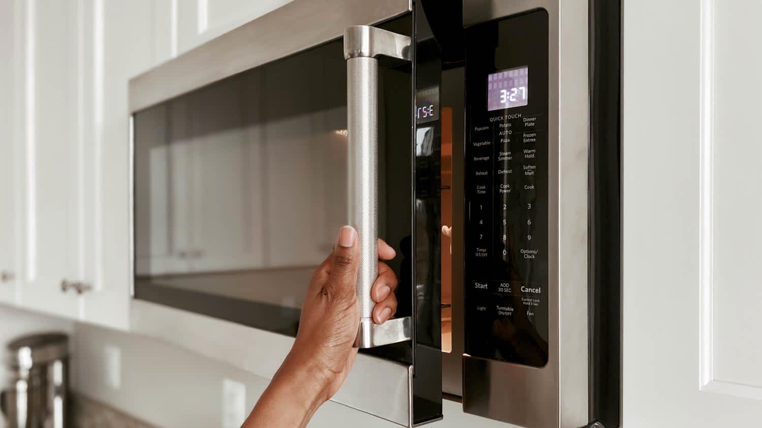 A woman opening a microwave
