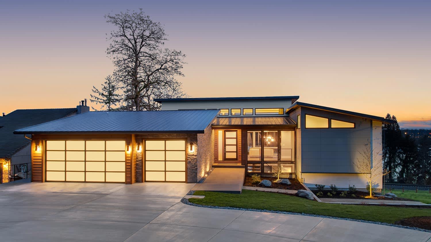The exterior of an illuminated contemporary house at dusk