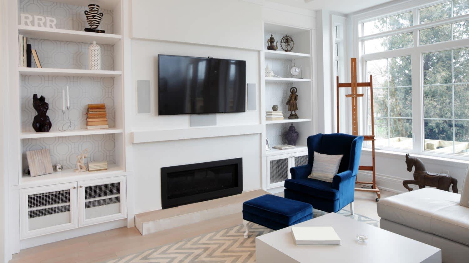 living room with blue chair and TV mounted on the wall