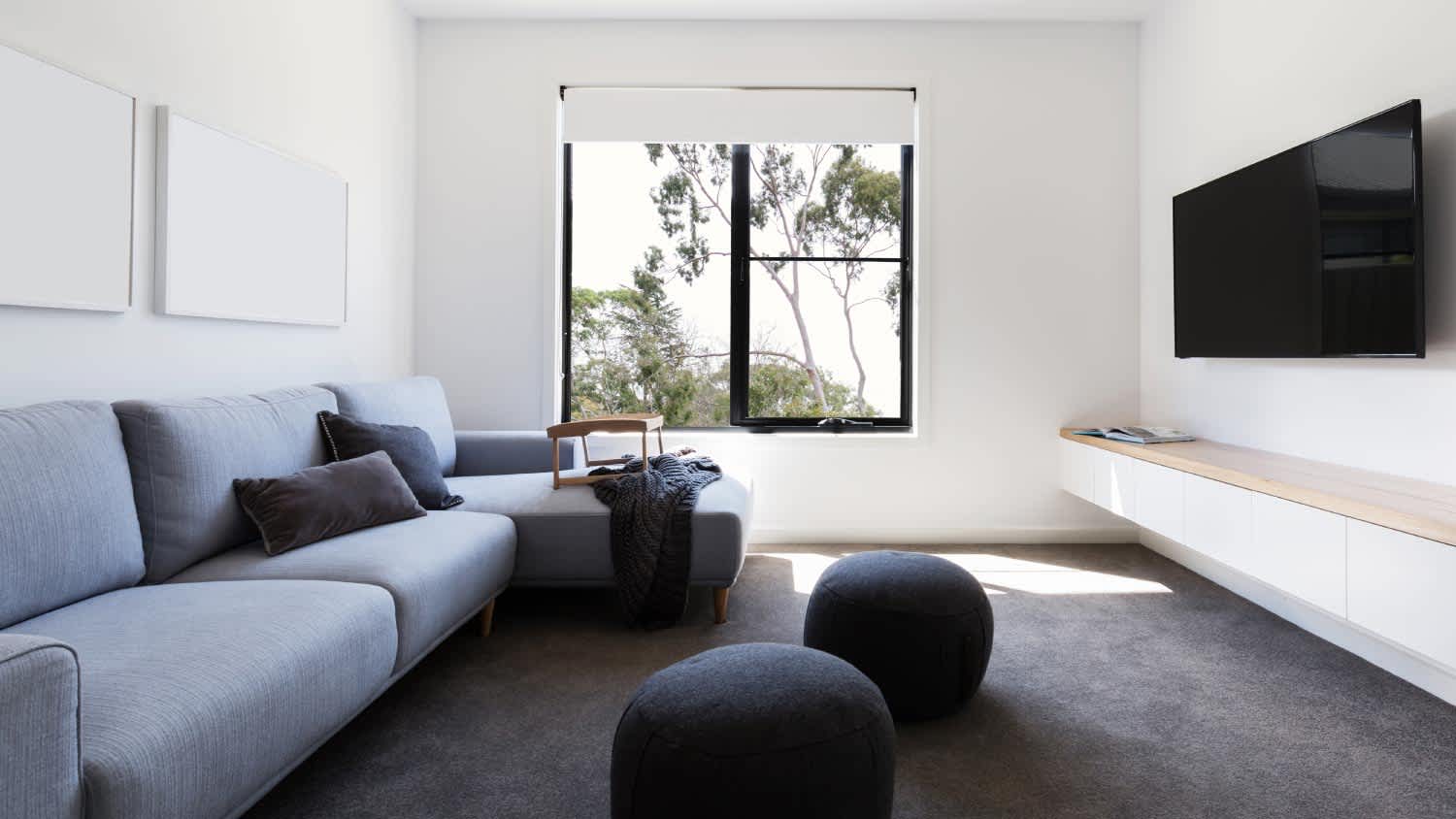 living room with blue sectional sofa and TV on the wall