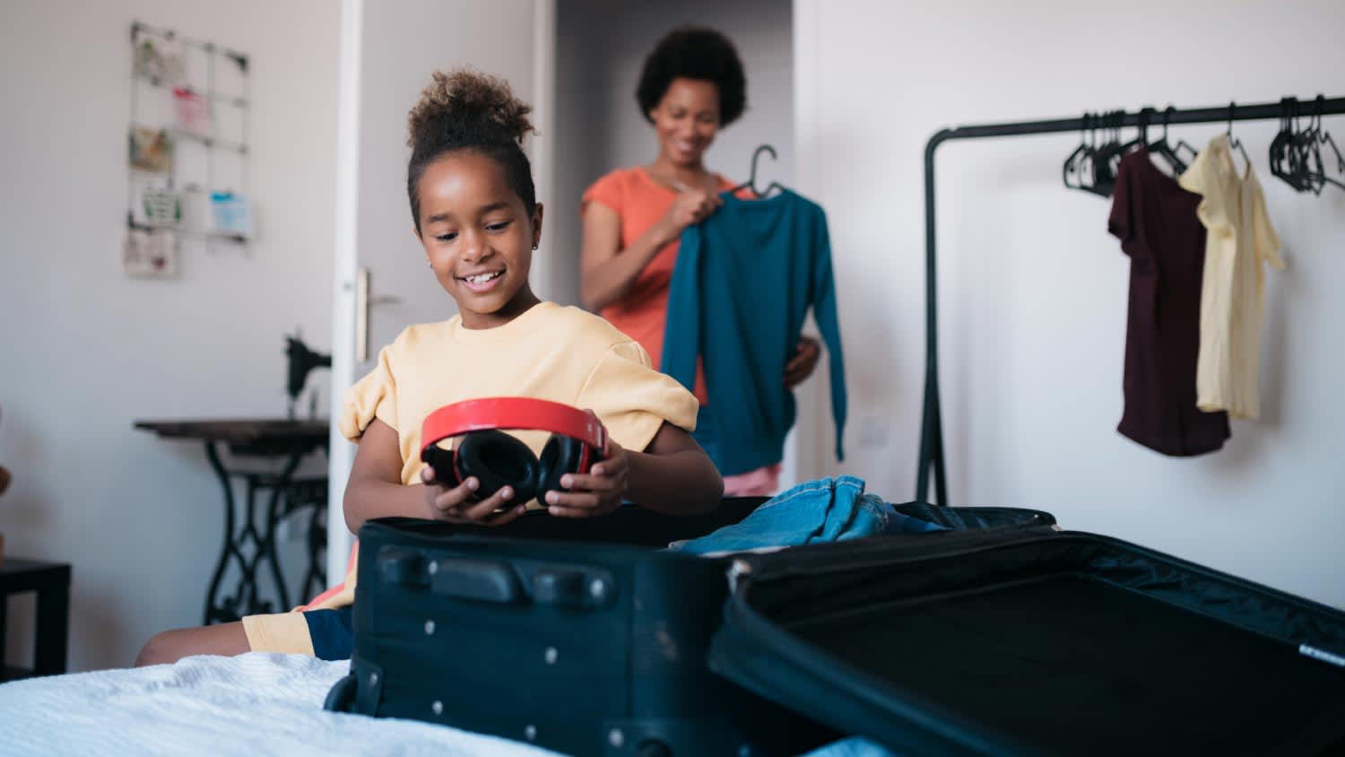 mother and daughter packing a suitcase
