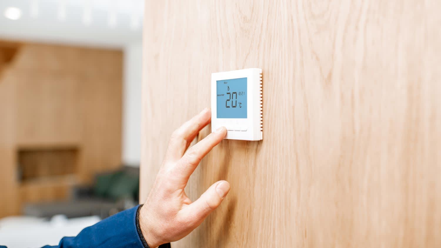 closeup of a person's hand adjusting the thermostat