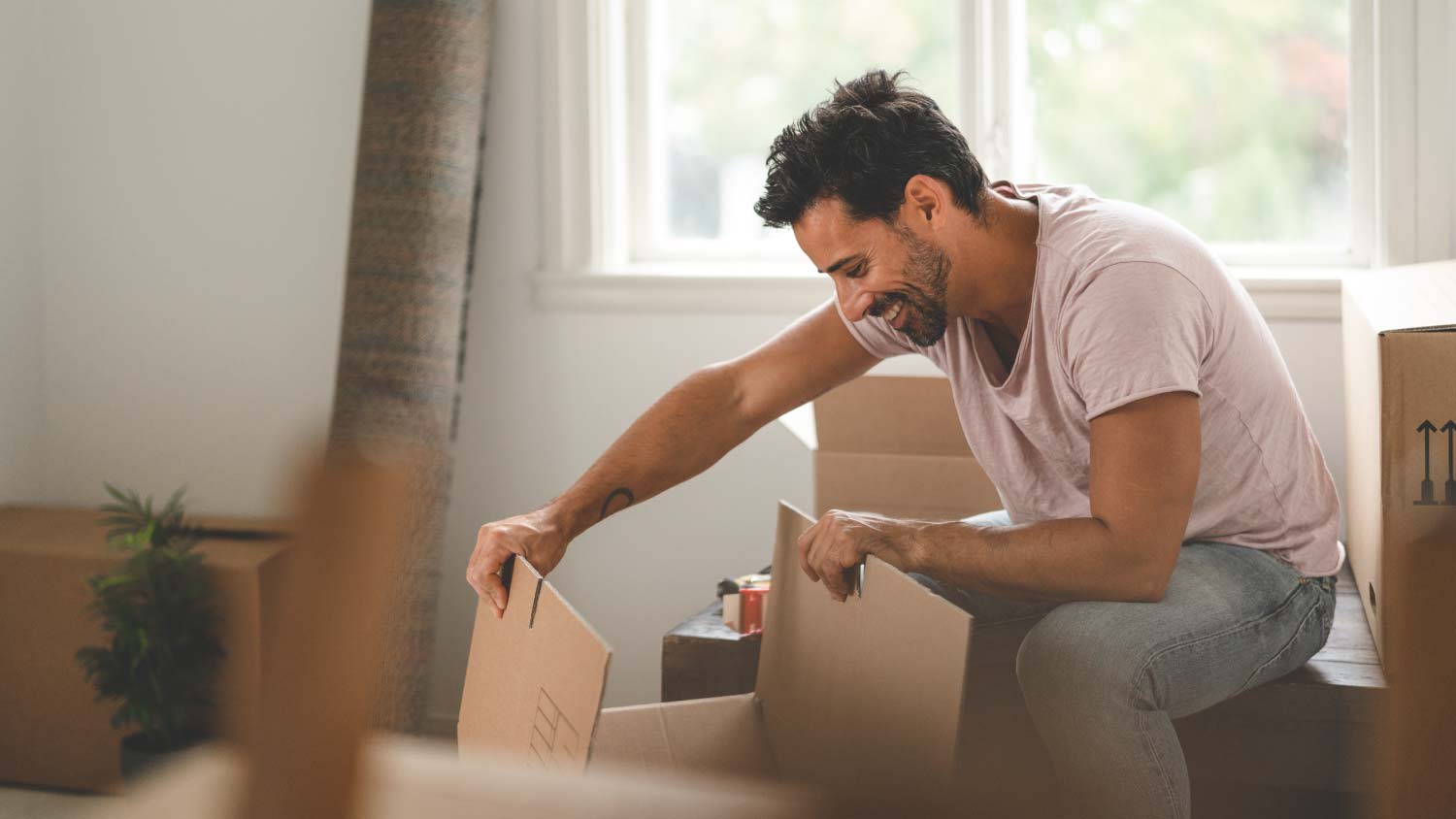 A man unpacking in his new house