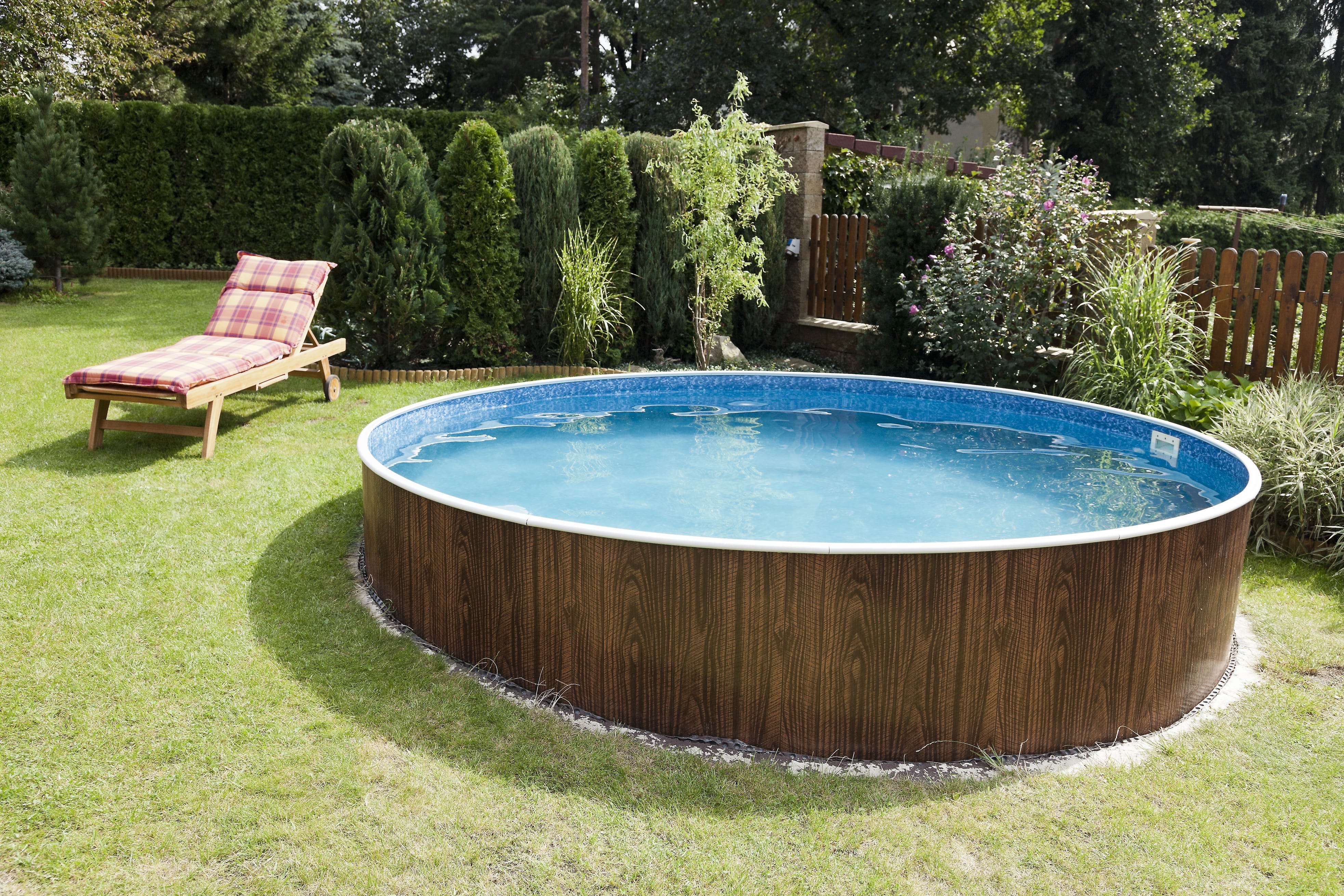 An above-ground pool with white landscaping rocks around the perimeter
