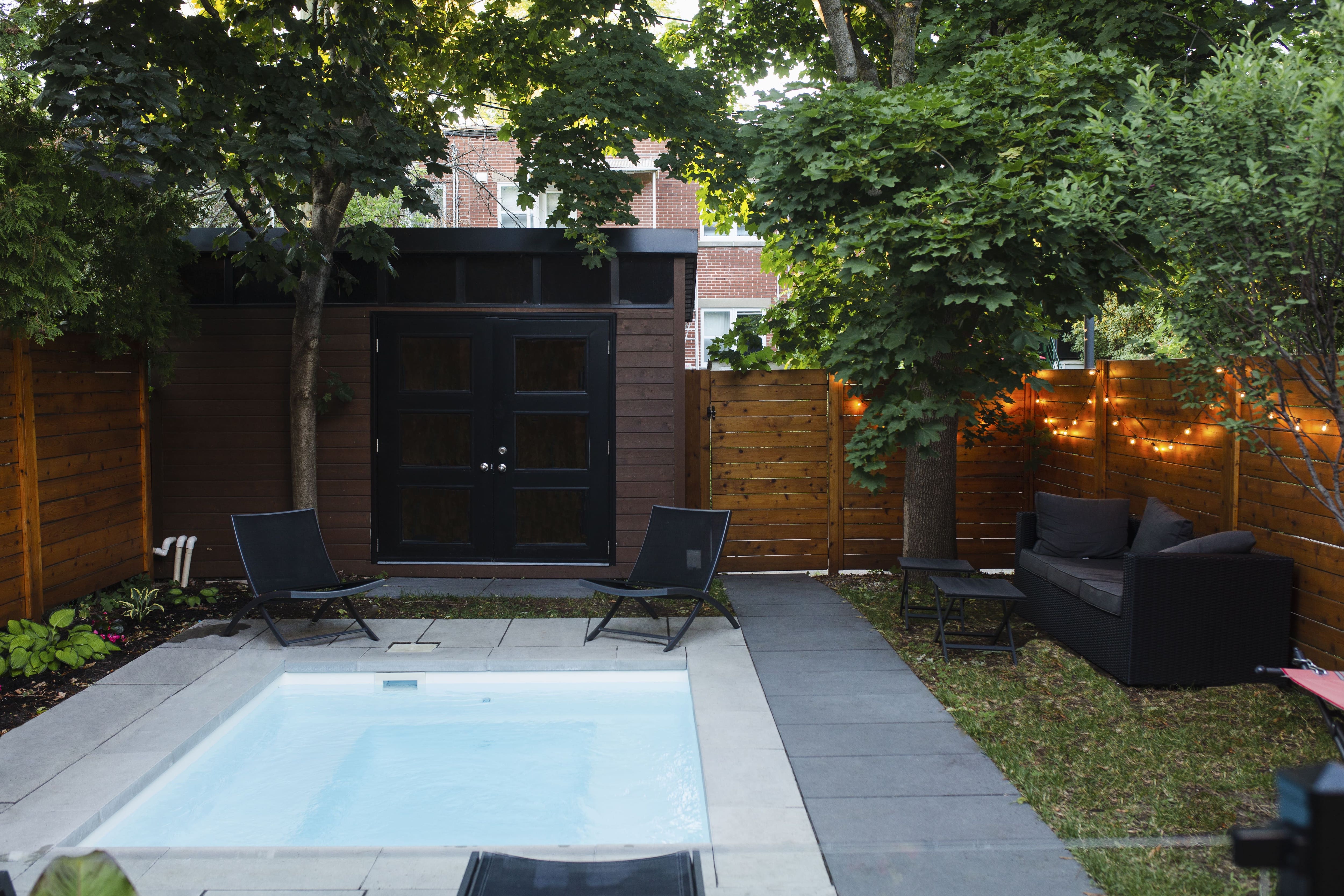 A small backyard with a small in-ground pool