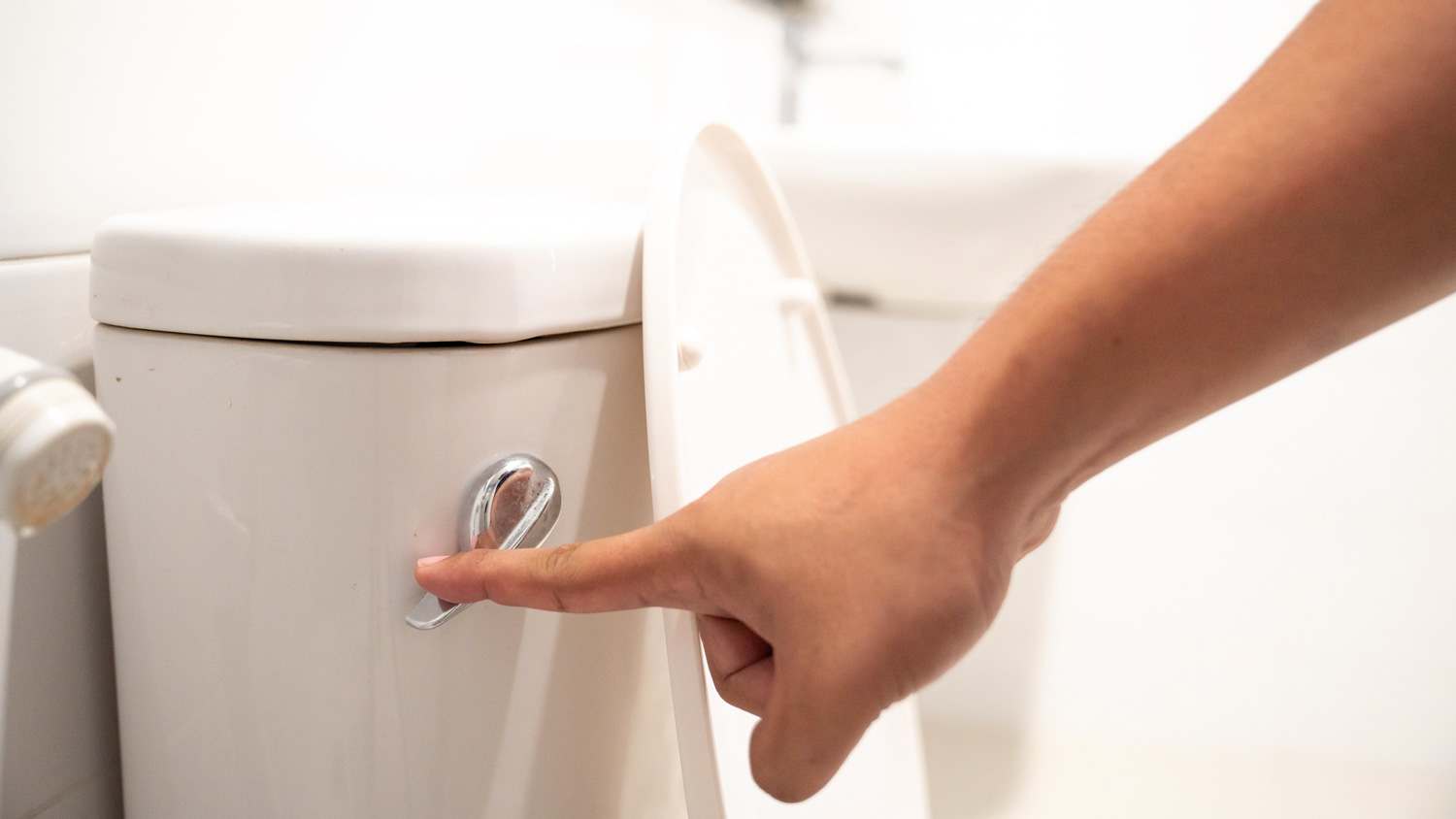 A woman flushing down the toilet