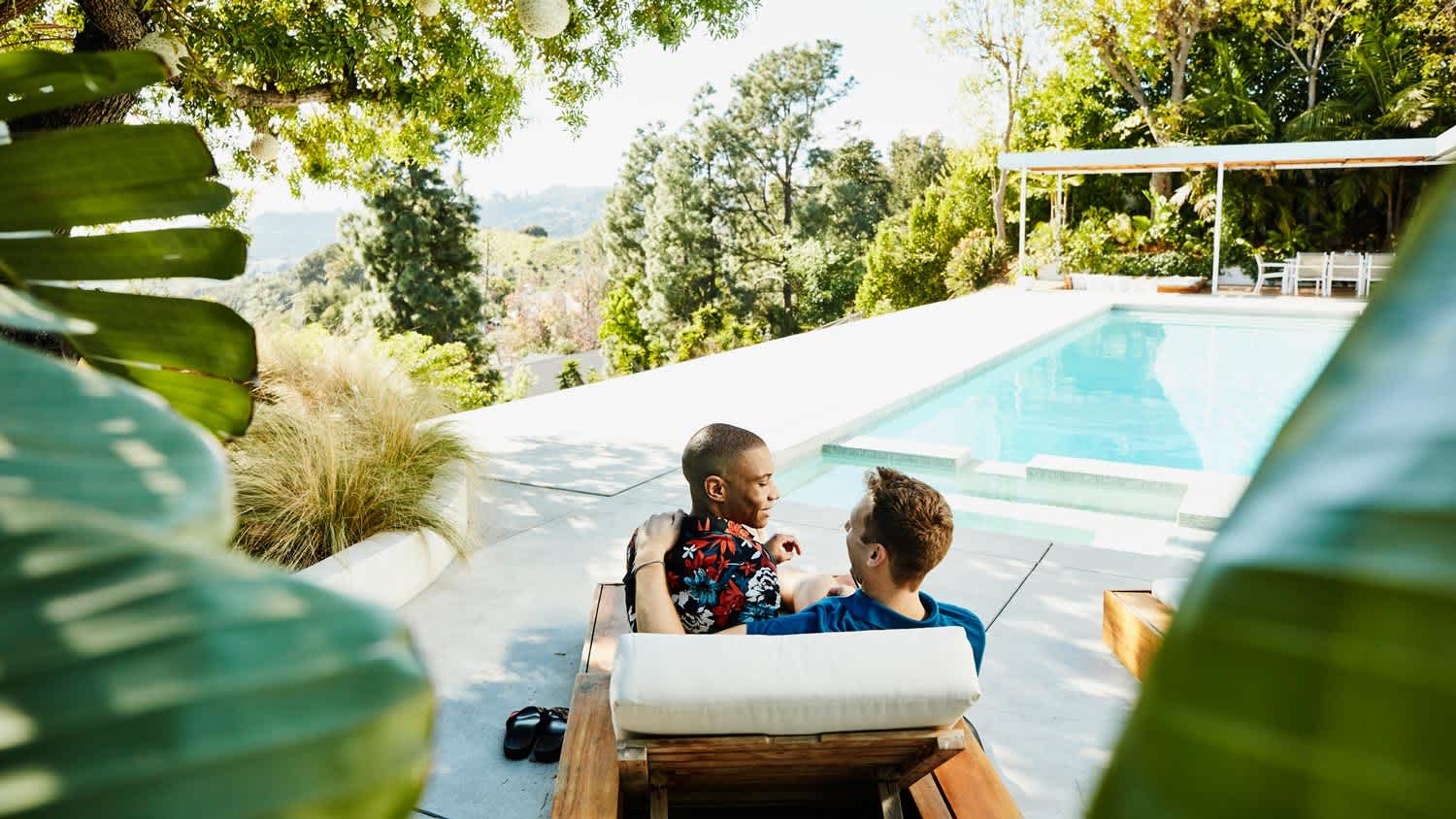 A couple sitting together at a pool deck
