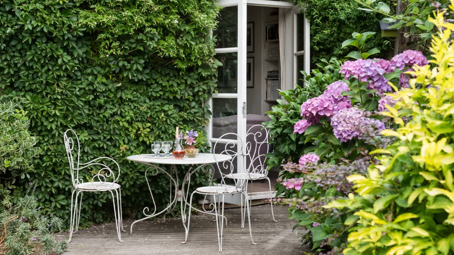 A garden with white wrought iron furniture