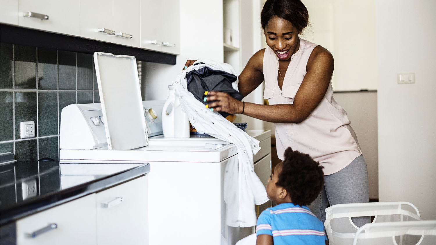little son helping mom loading the washer