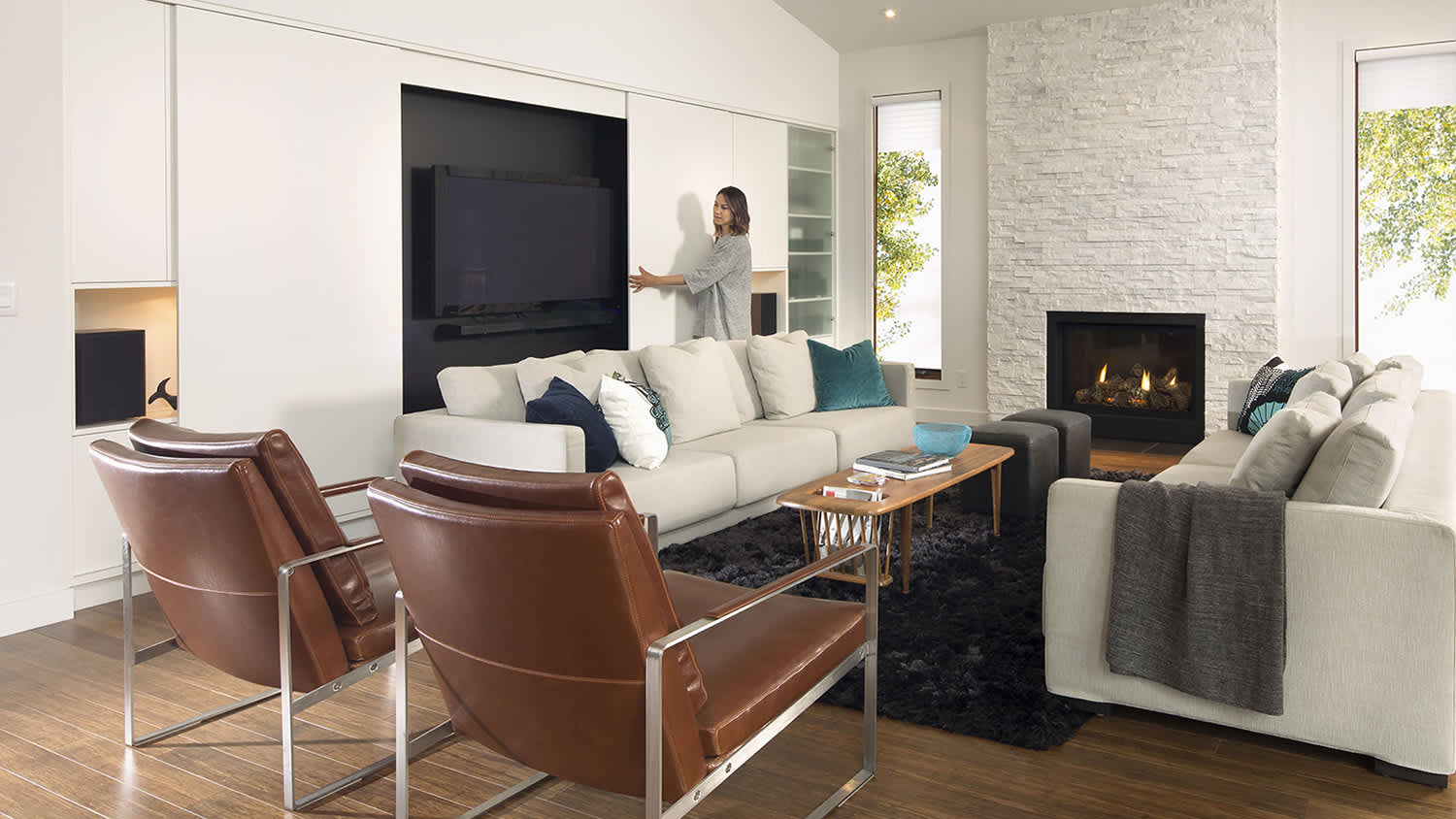 woman sliding cabinet door to expose TV