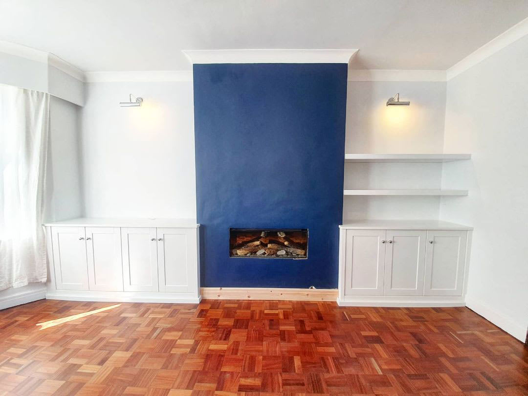 Blue plaster fireplace with white cabinetry