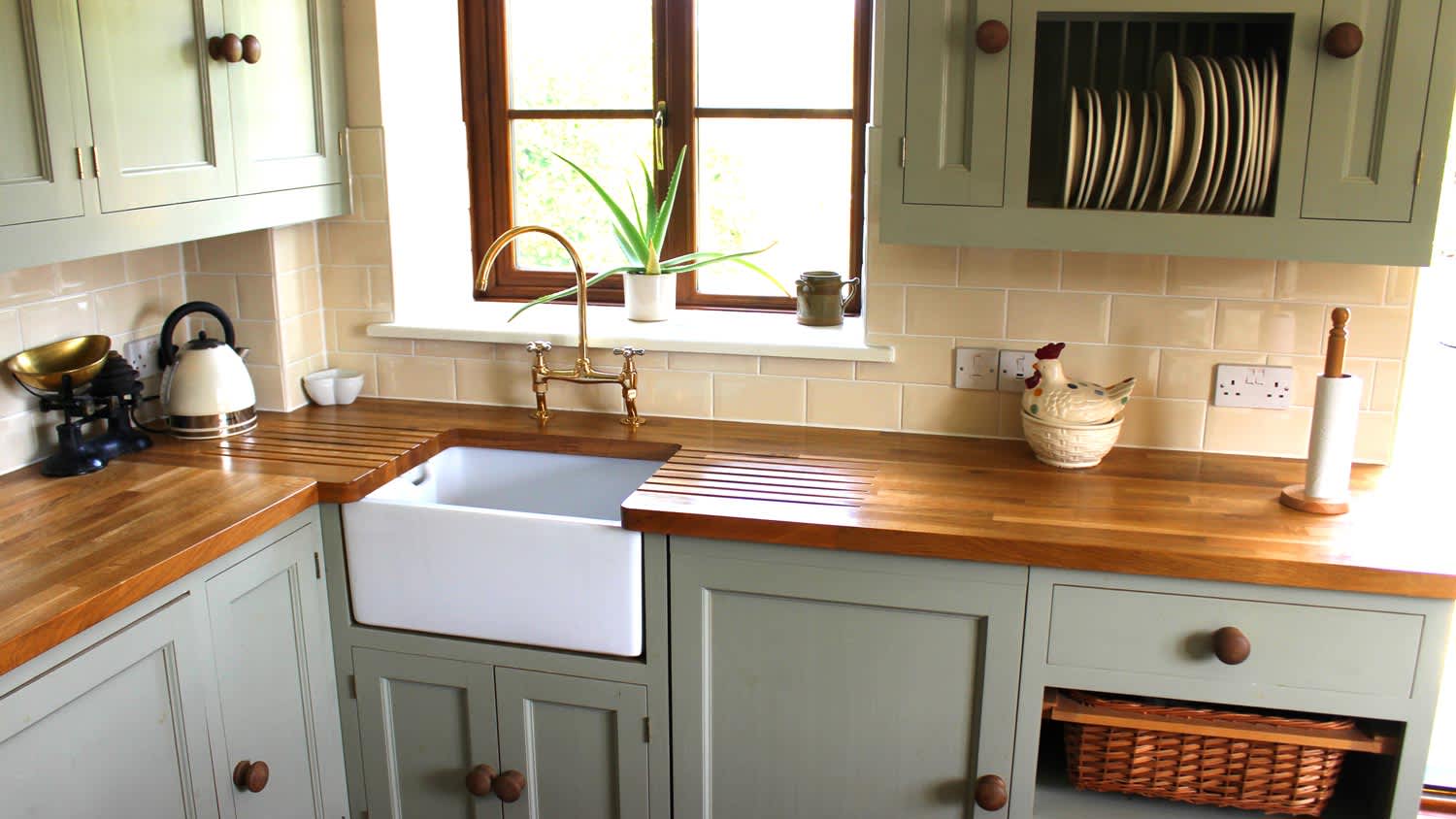 A white porcelain deep sink in a kitchen with wooden countetops