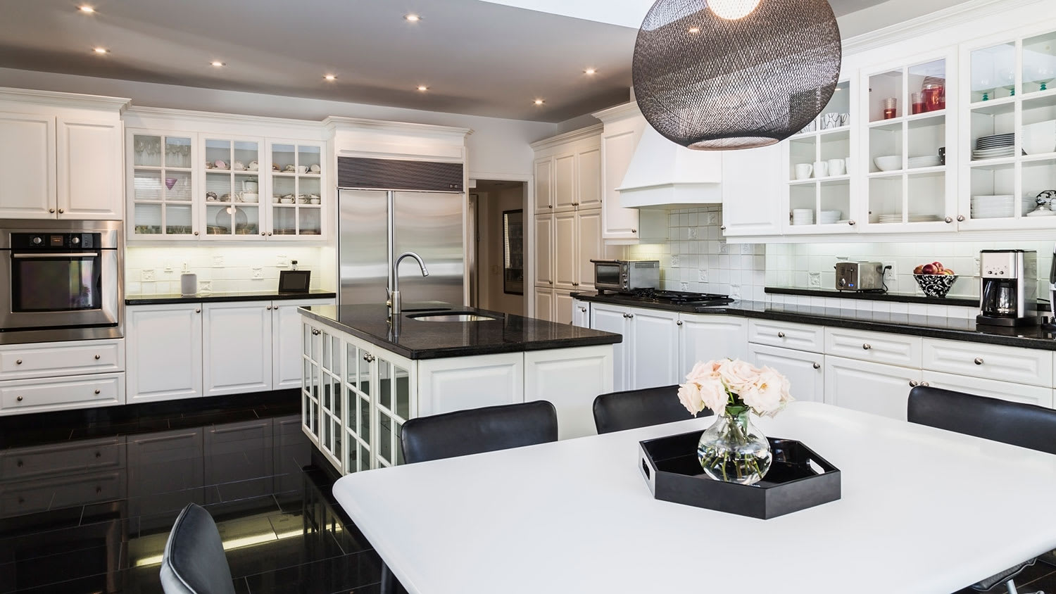 White breakfast table with black leather chairs