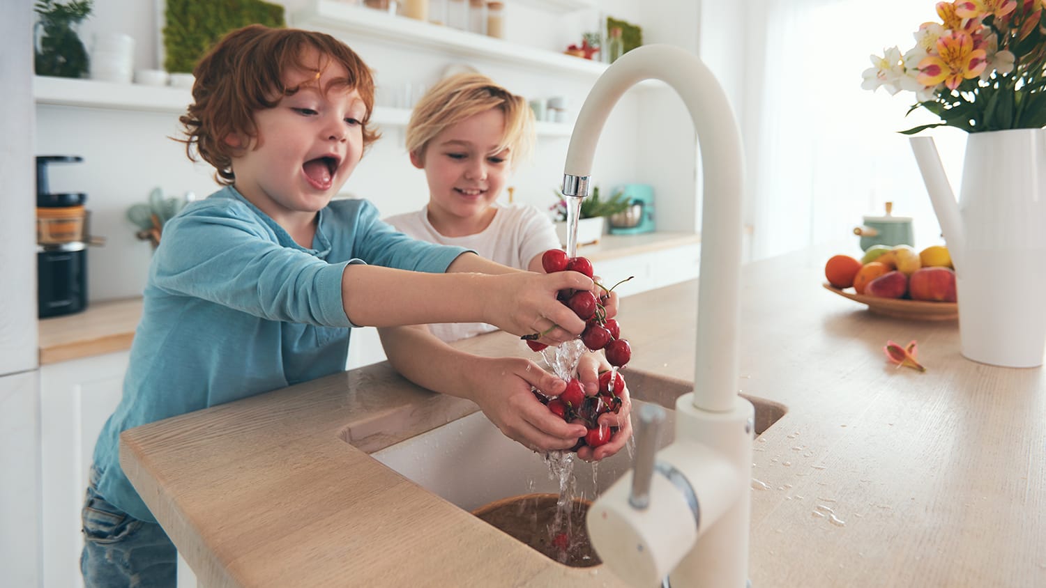 Kids washing cherries at the kitchen sink