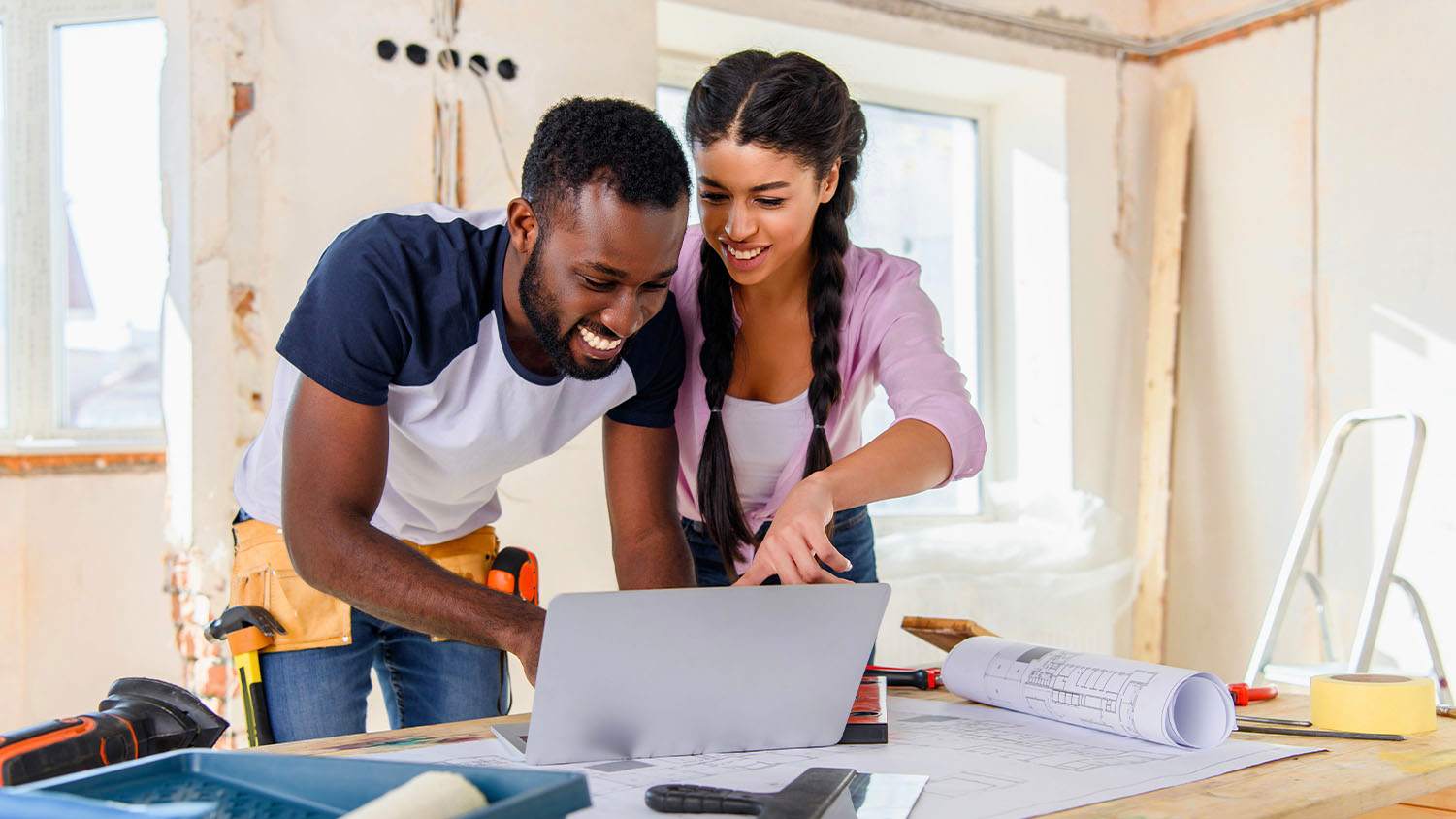 couple looking at home blueprint plans on laptop