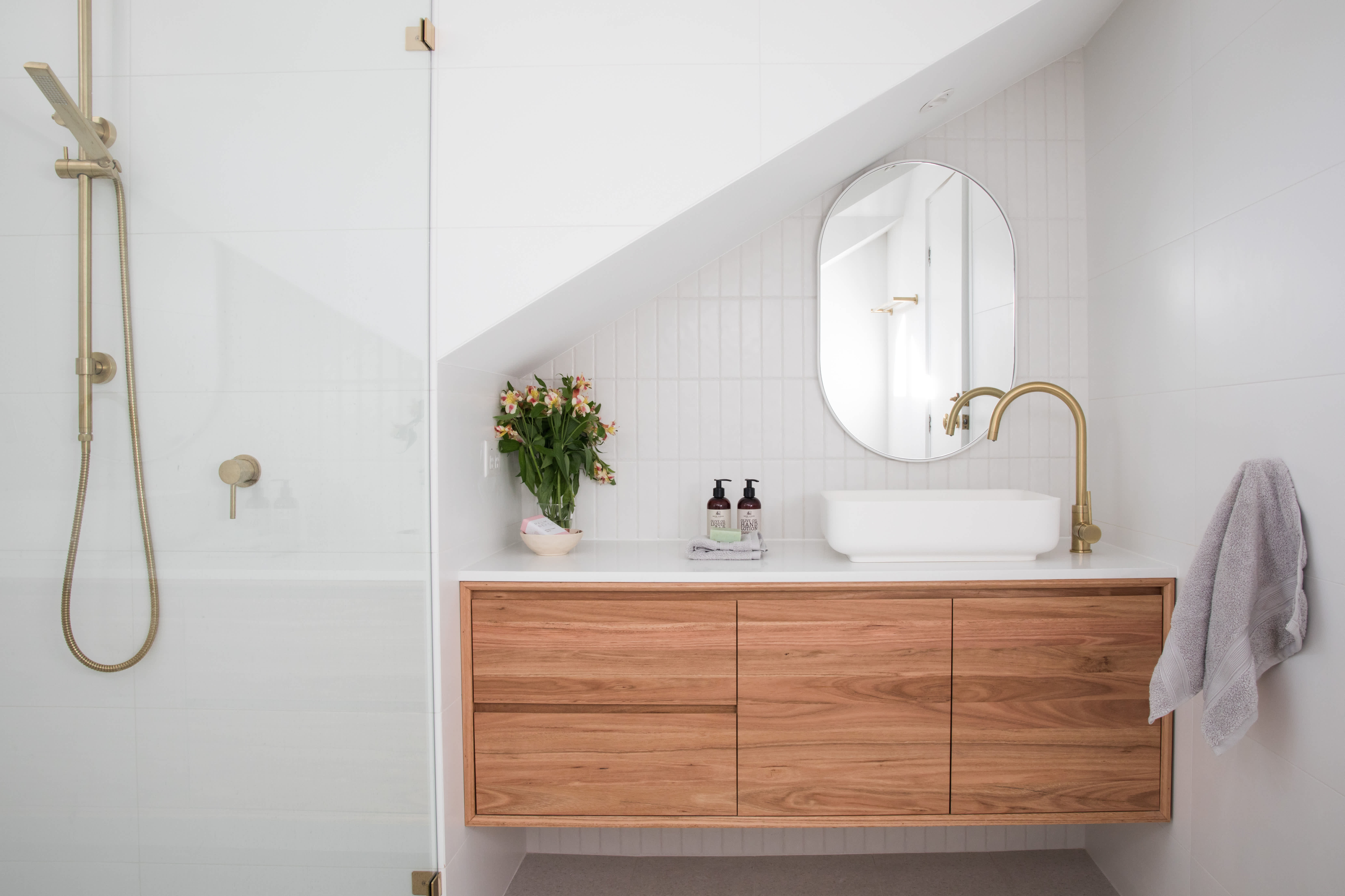 An offset wooden vanity in a modern bathroom