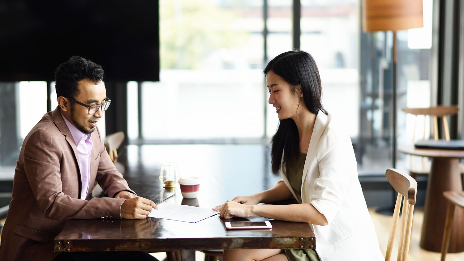 Man and woman signing printed documents