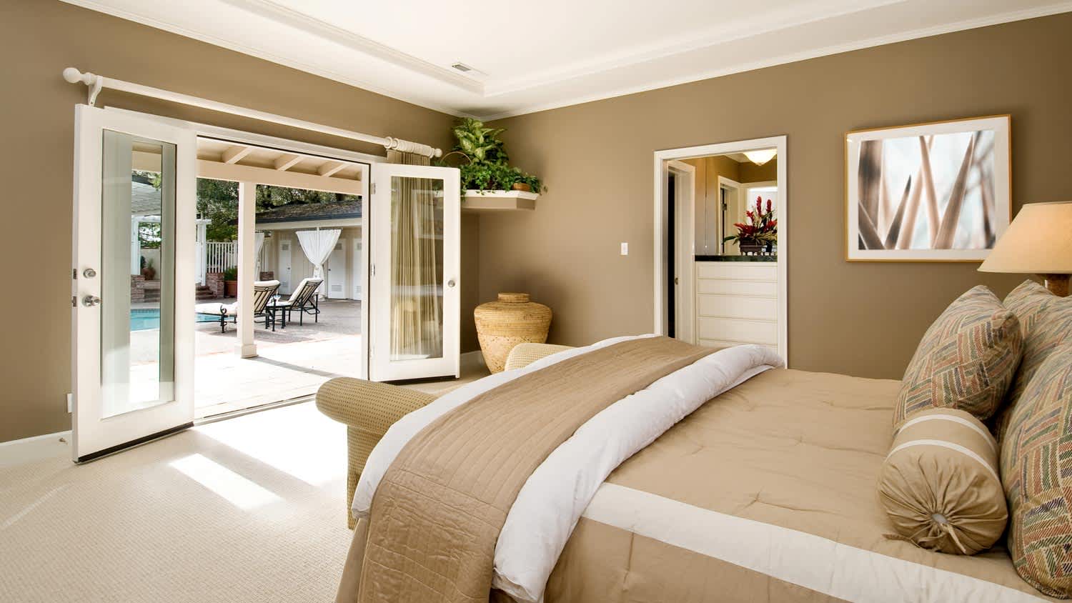 A bedroom leading to a patio and a pool
