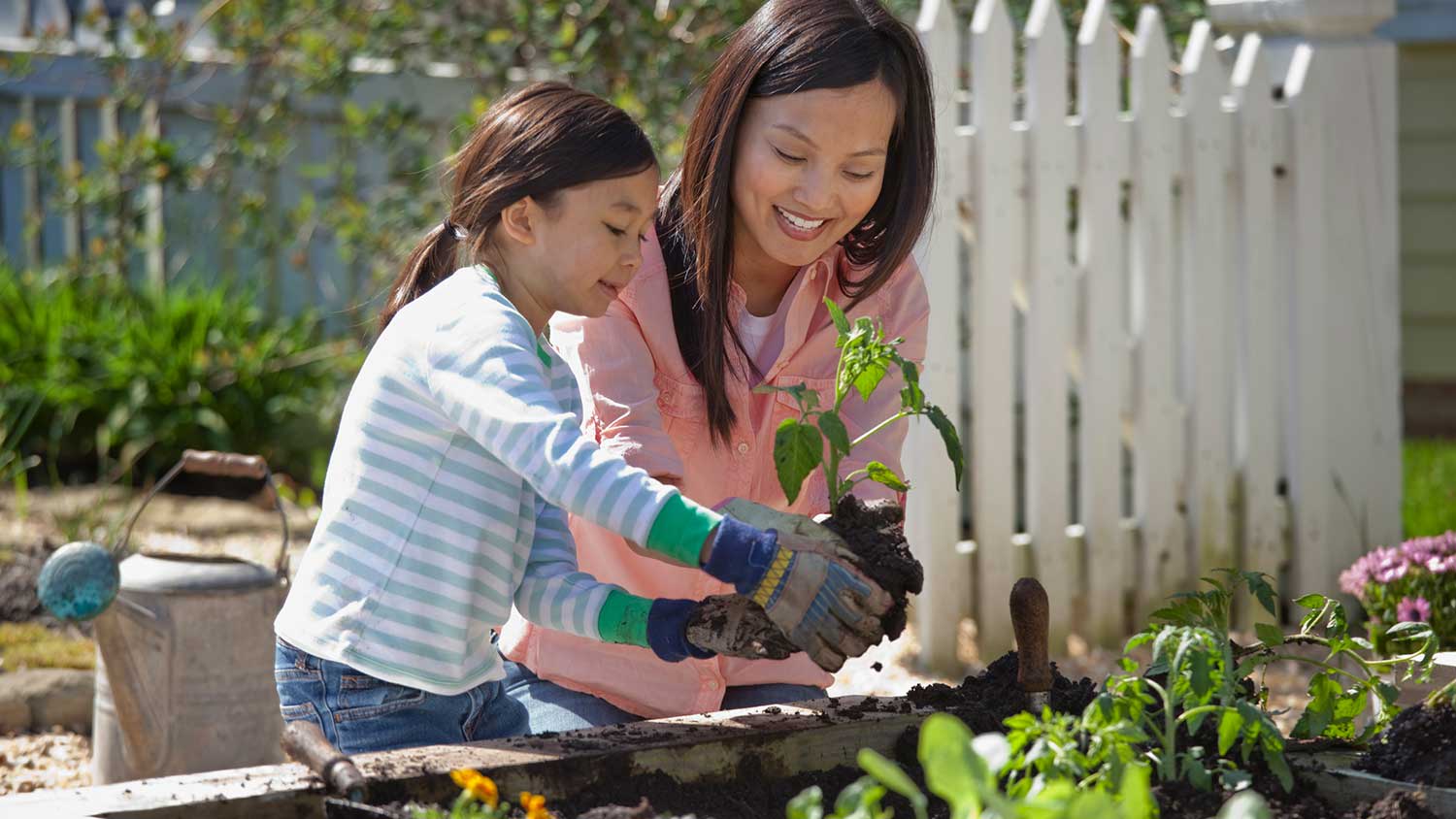 Daughter helping mom gardening at home