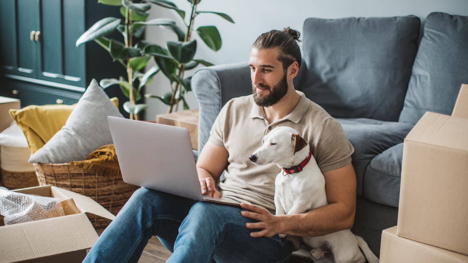 A man next to his pet using laptop