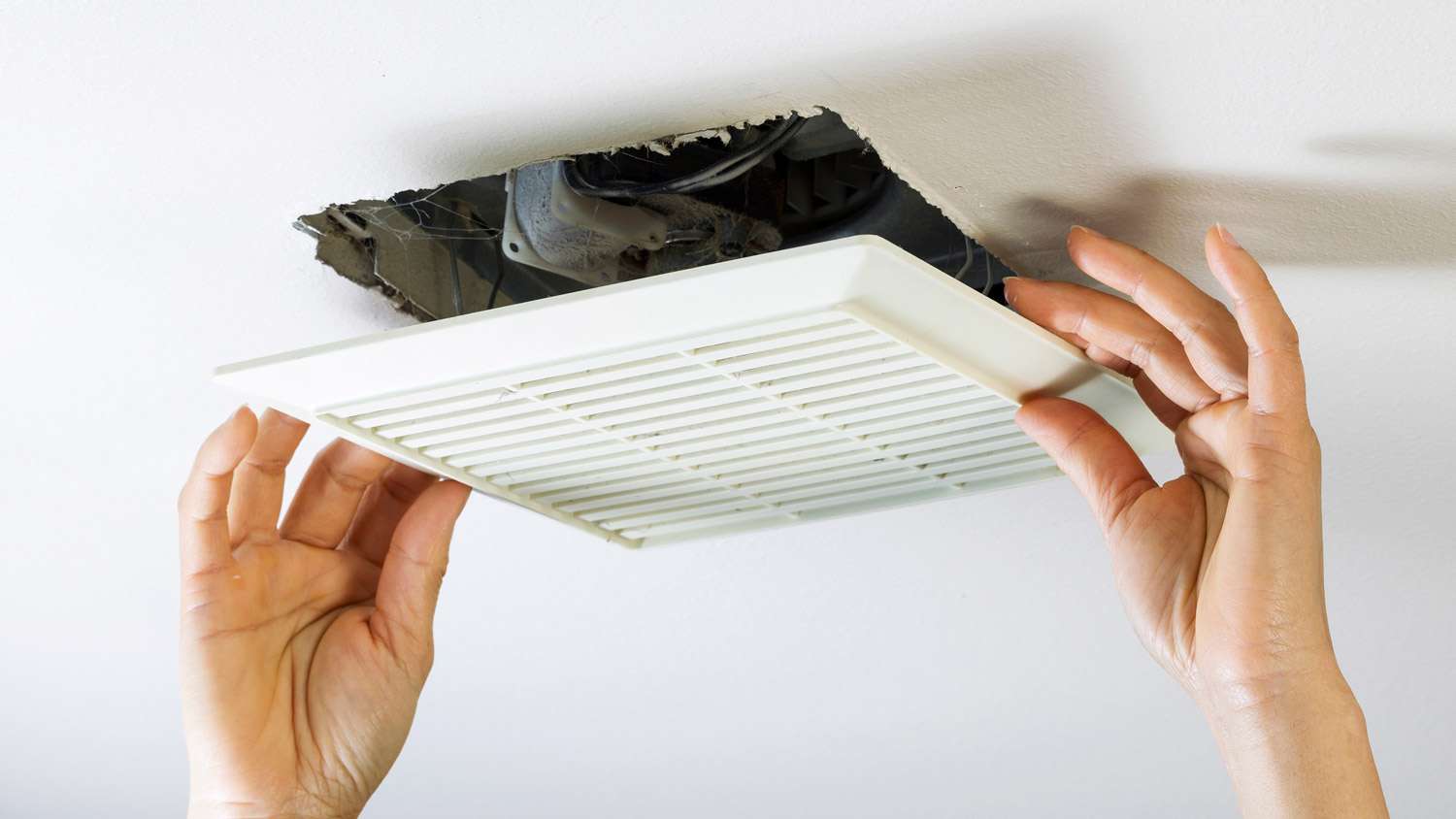 A woman cleaning an air duct