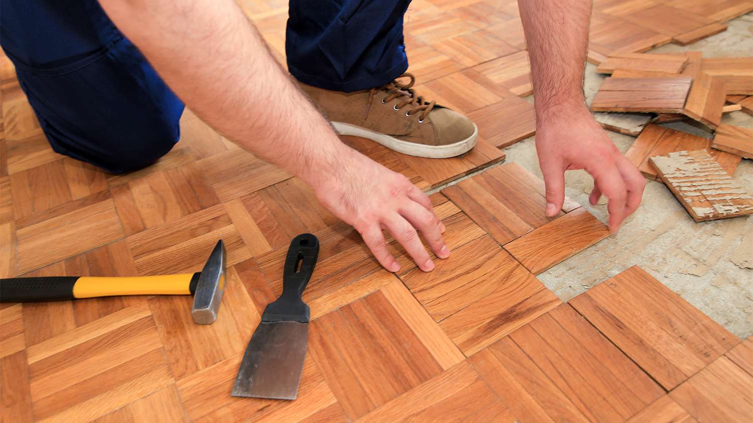 construction worker installing parquet flooring