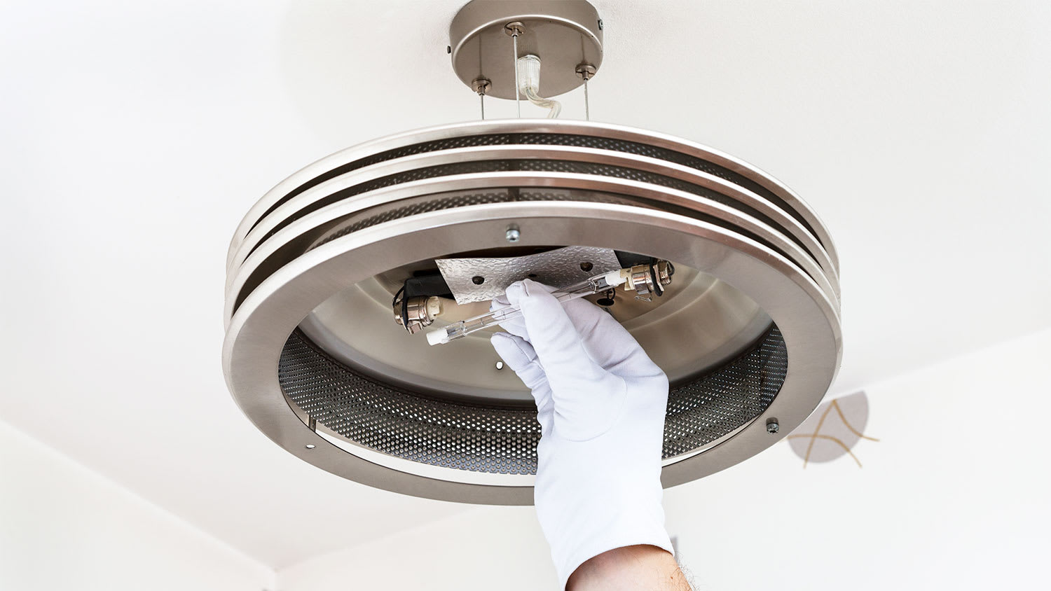 Gloved hand installing halogen light bulb