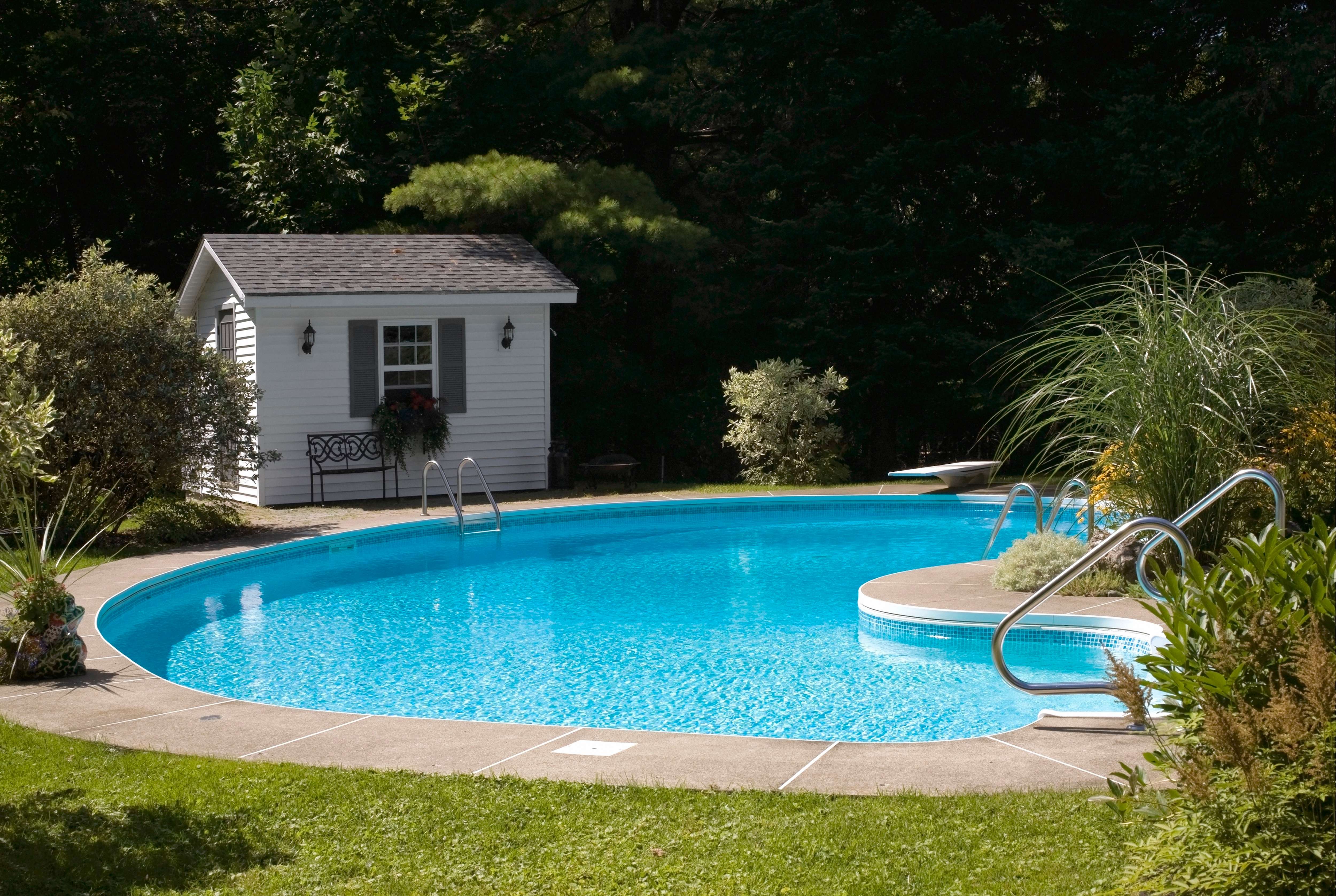 An inground pool and a pool house with a window