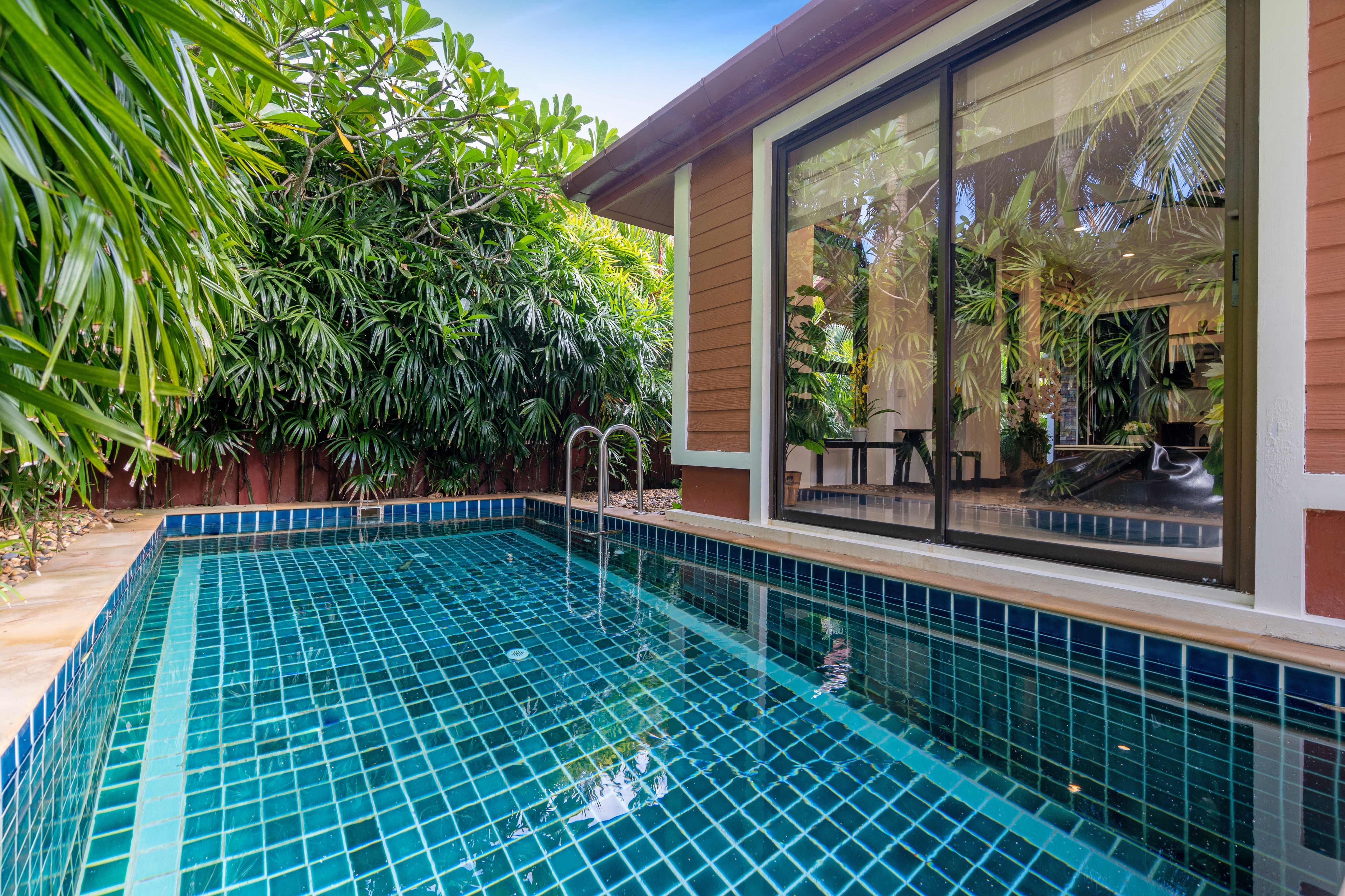 A poolside house with a sliding glass door leading to an inground pool
