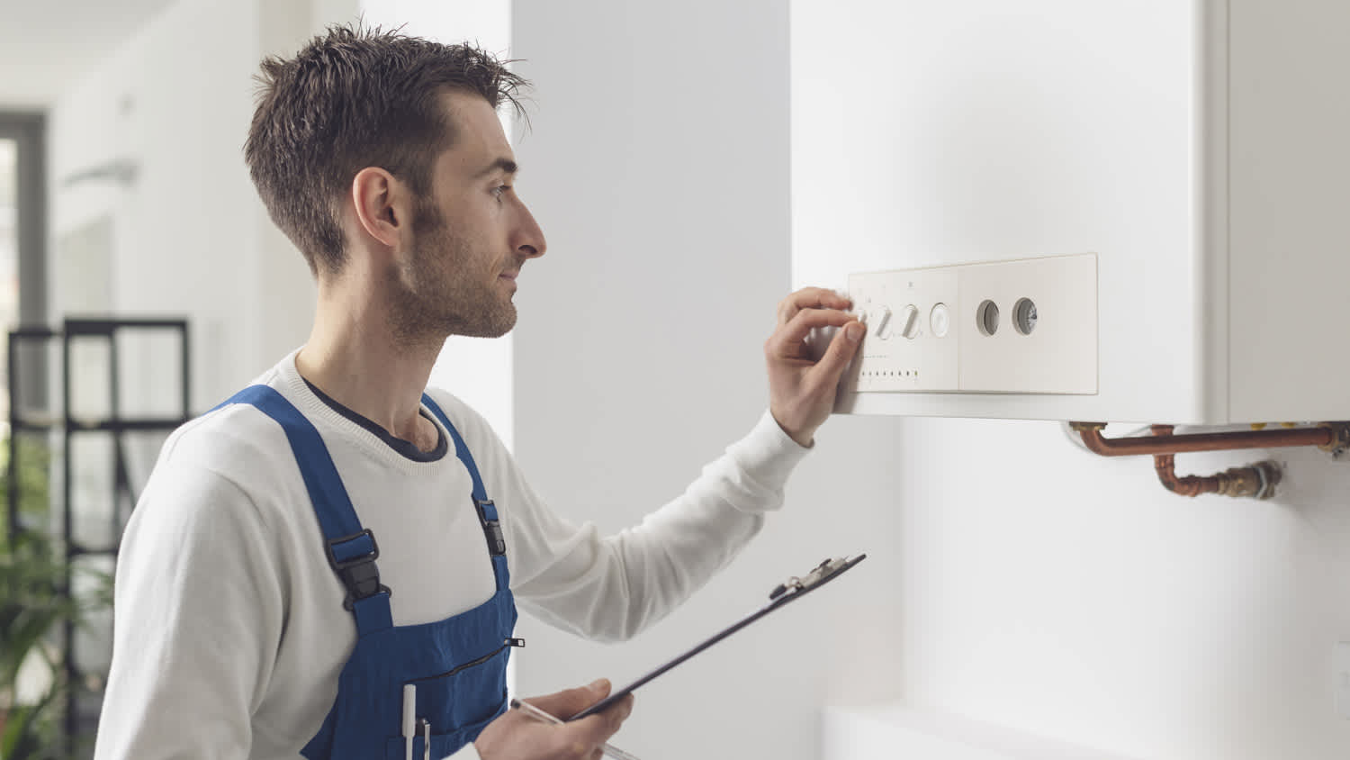 A professional adjusting the boiler settings
