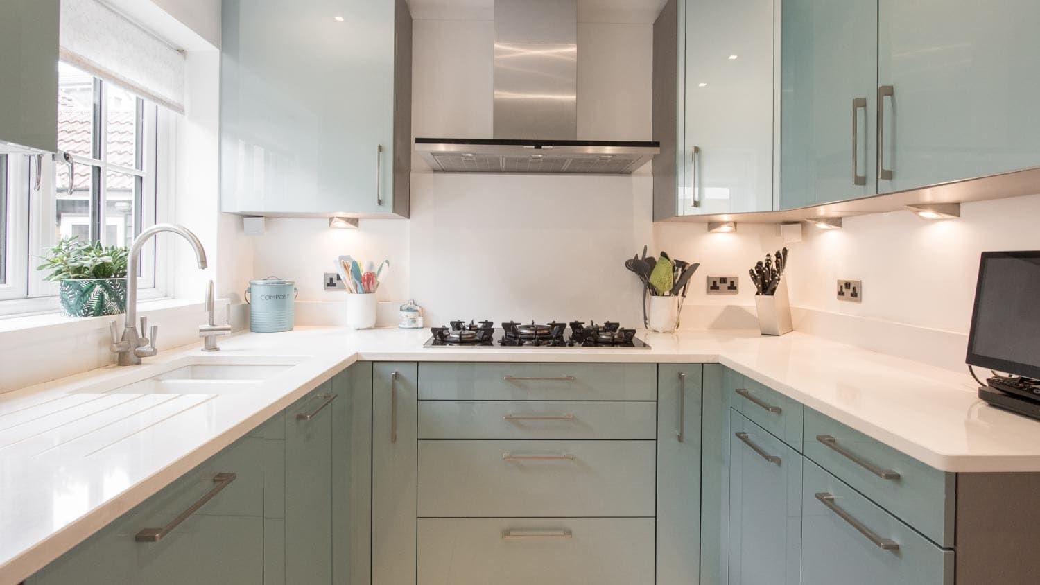 A general interior view of a modern metallic green fitted kitchen