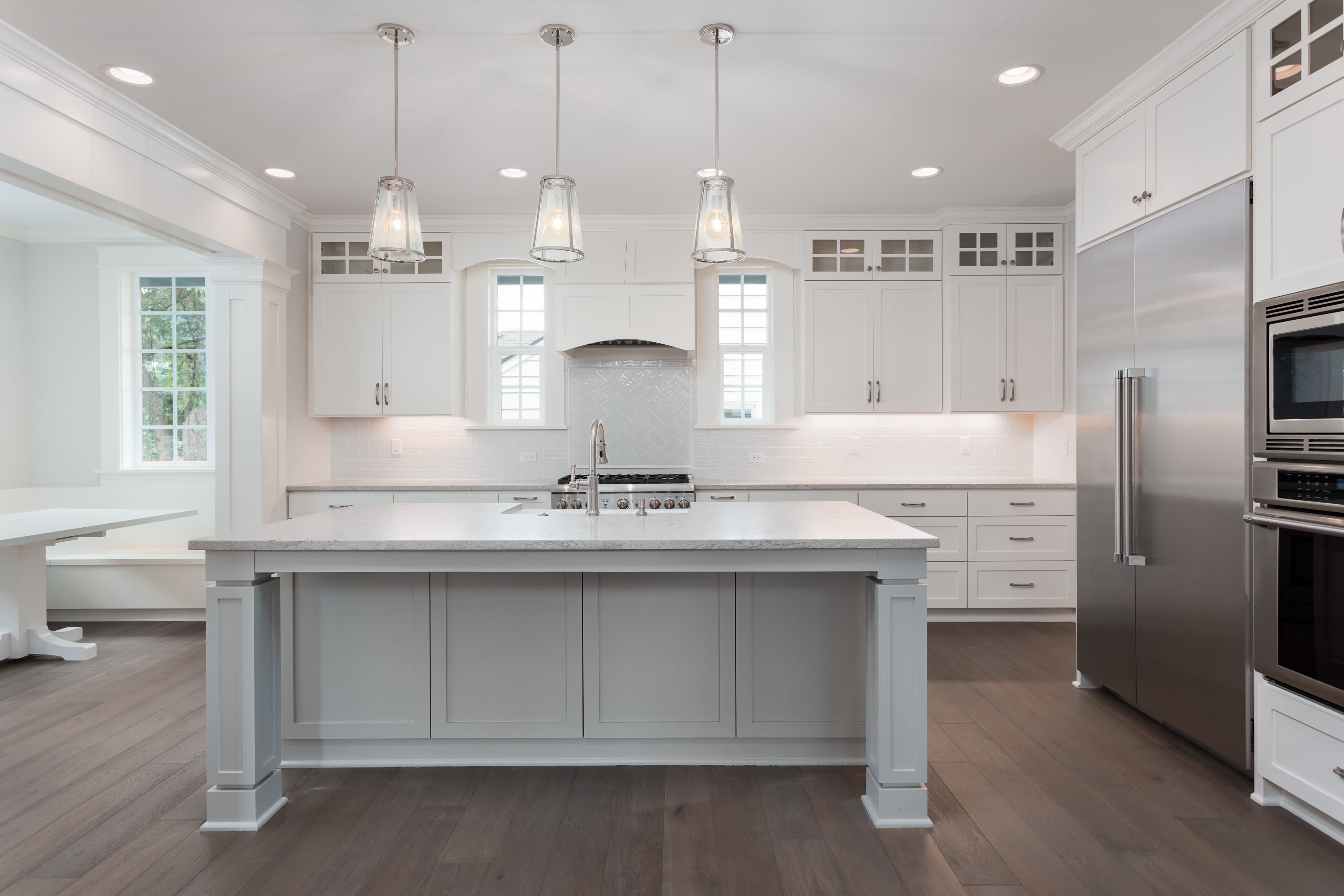 Large modern kitchen with white aesthetic and kitchen island with wainscoting features