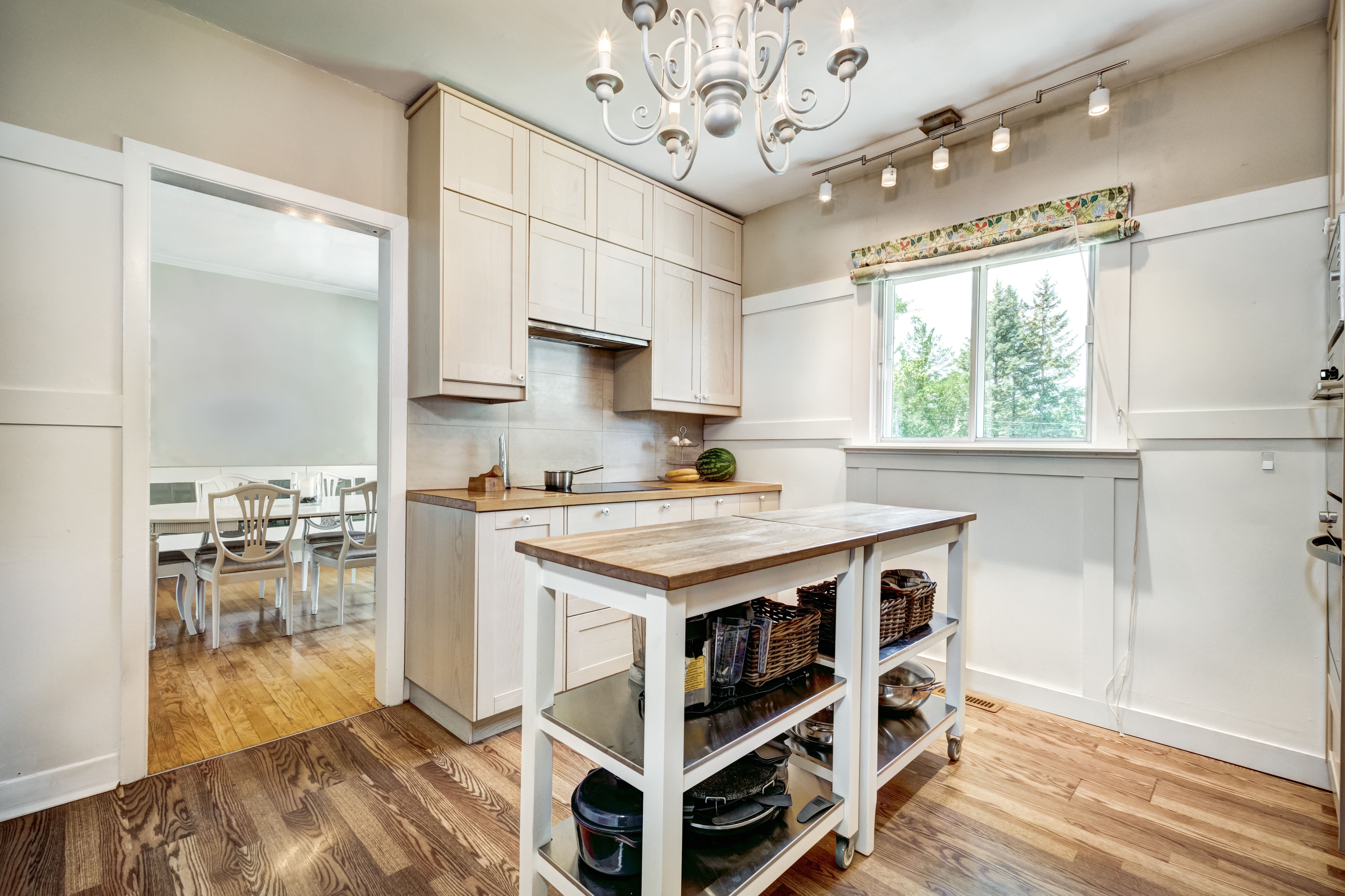 Country style small kitchen with broad paneled wainscoting on three-quarters of the wall