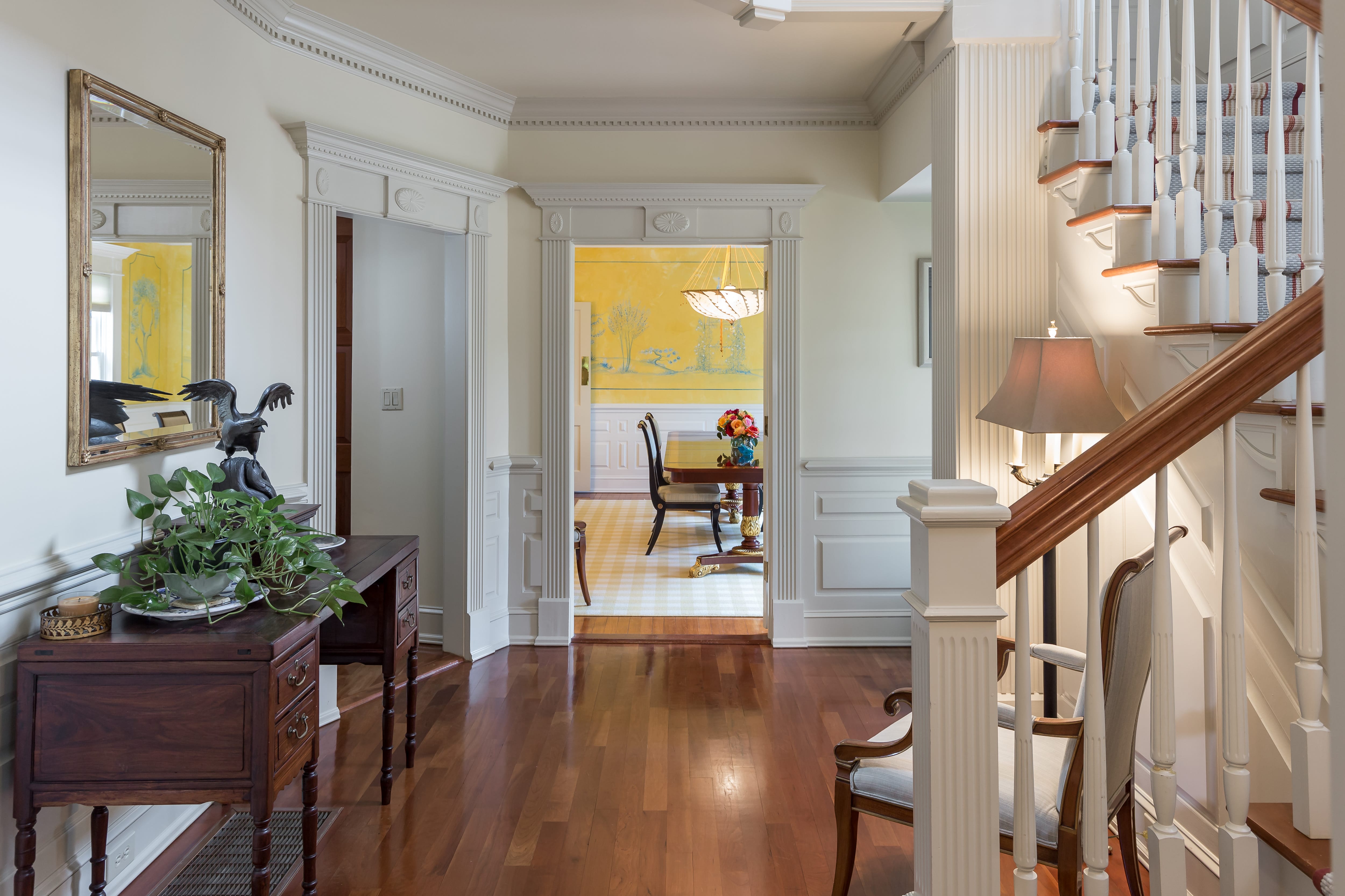 Elegant foyer of home with detailed white wainscoting