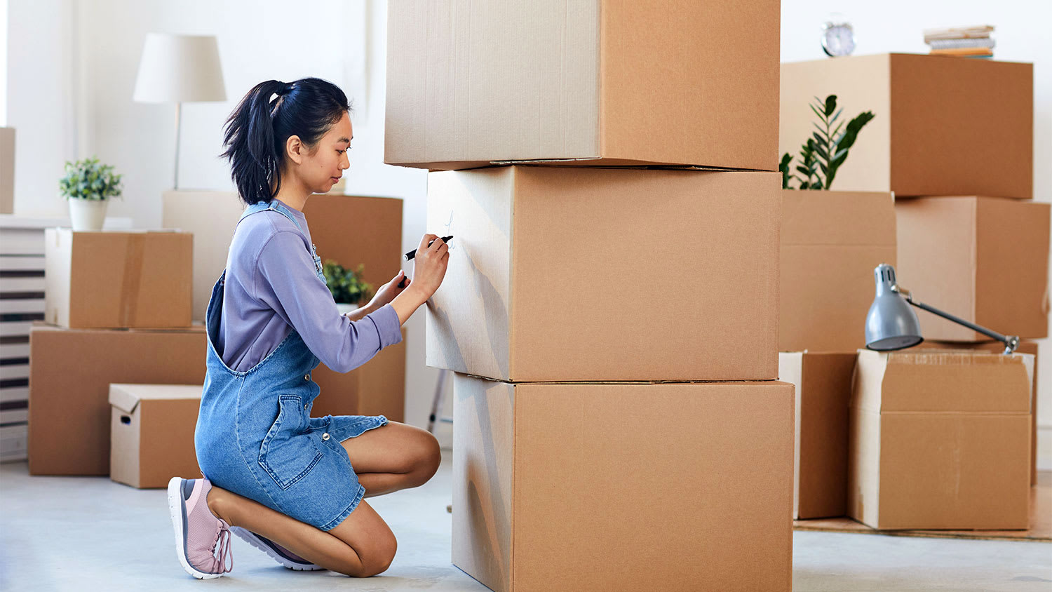 Woman labeling moving boxes