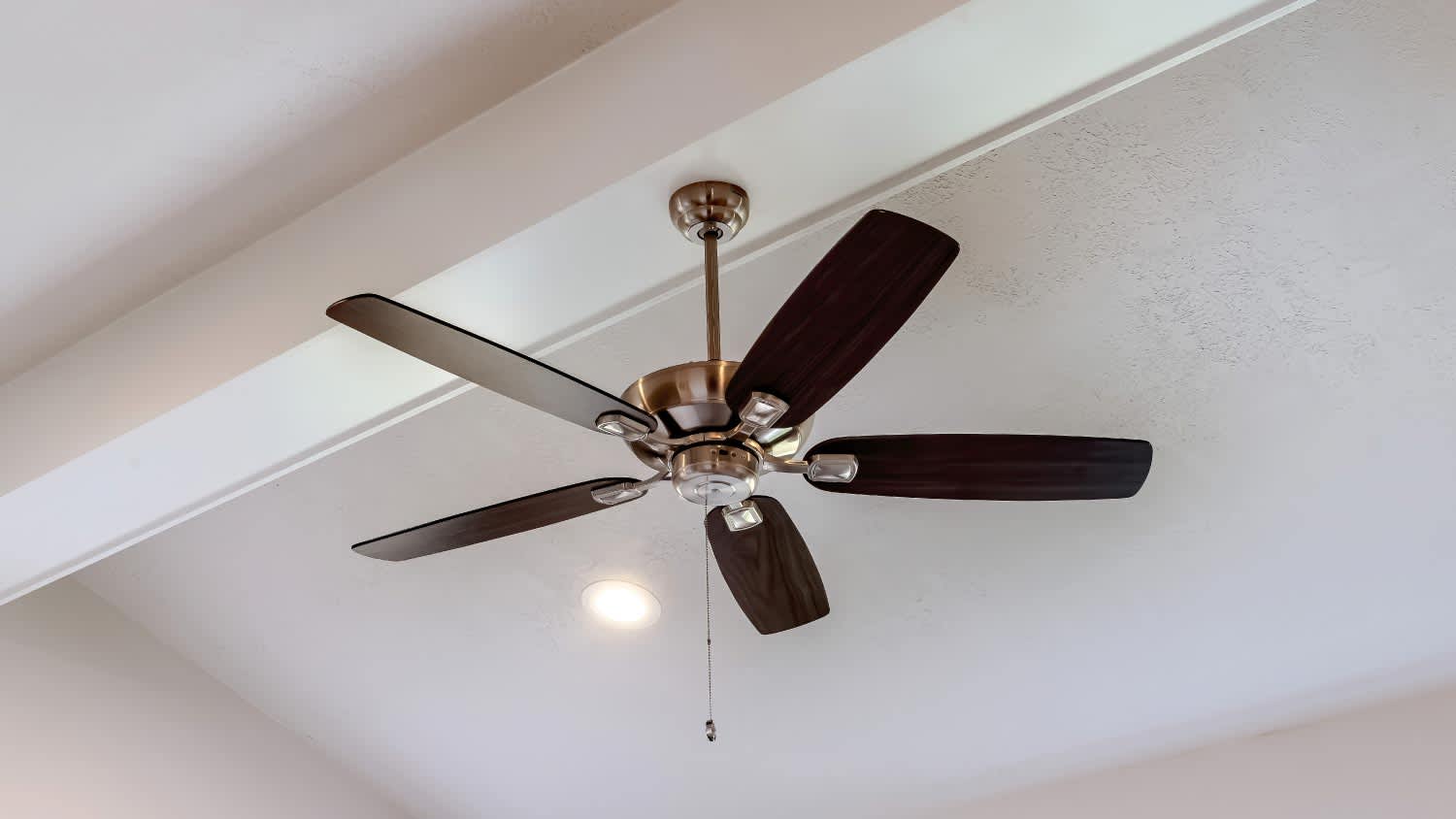 Decorative wood beam with standard ceiling fan