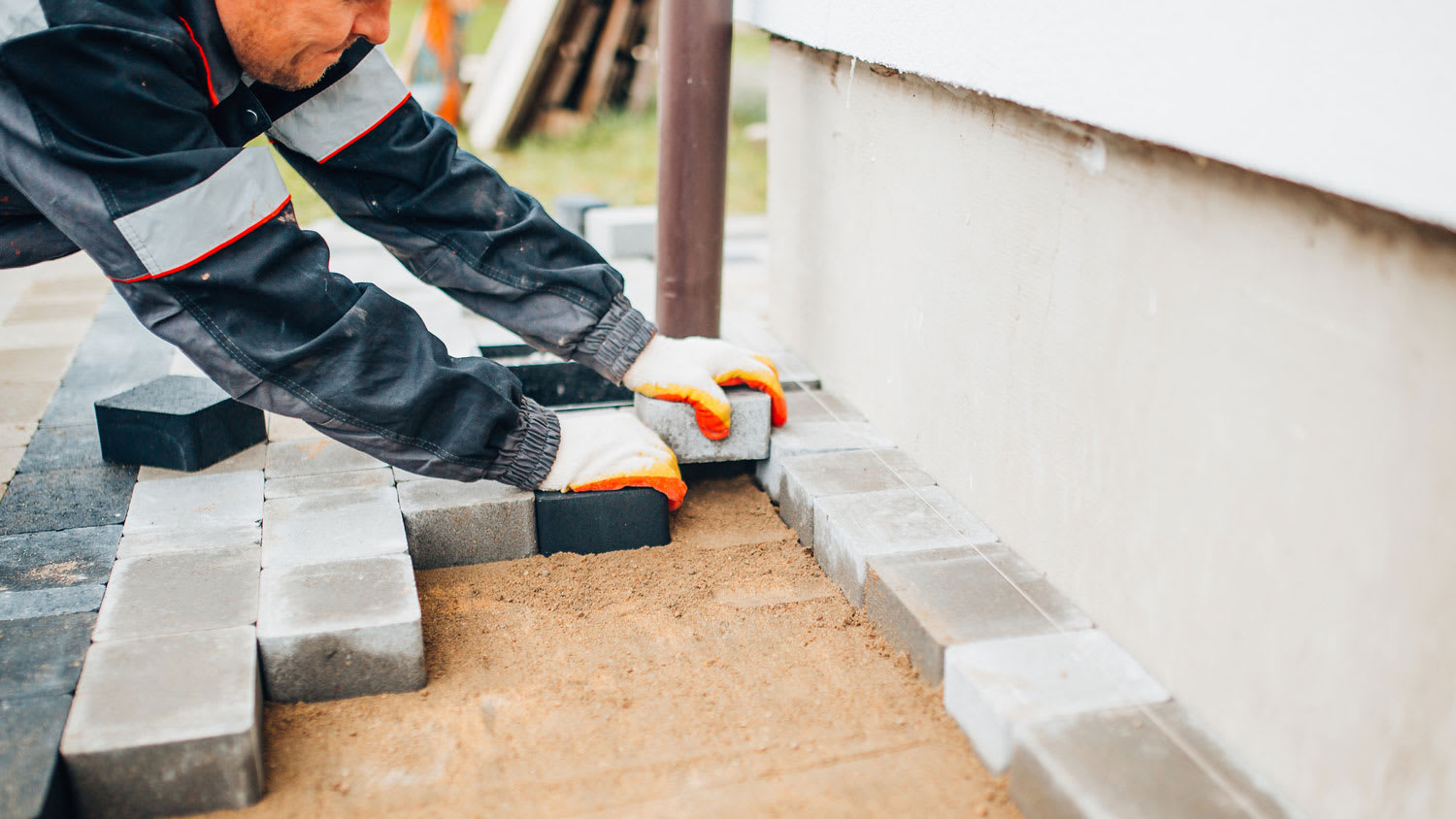 A professional laying new pavers