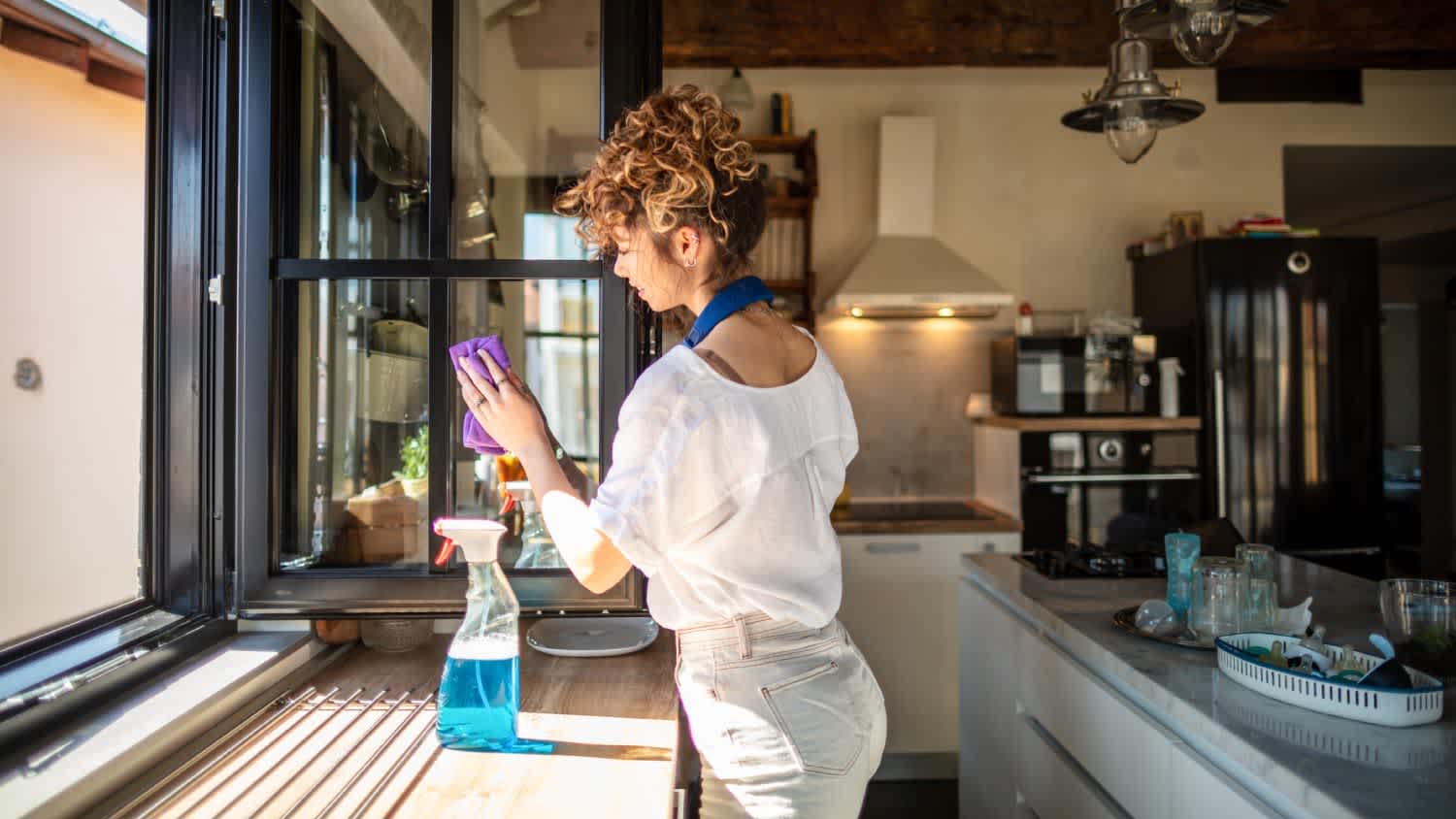 A woman cleaning a house’s windows