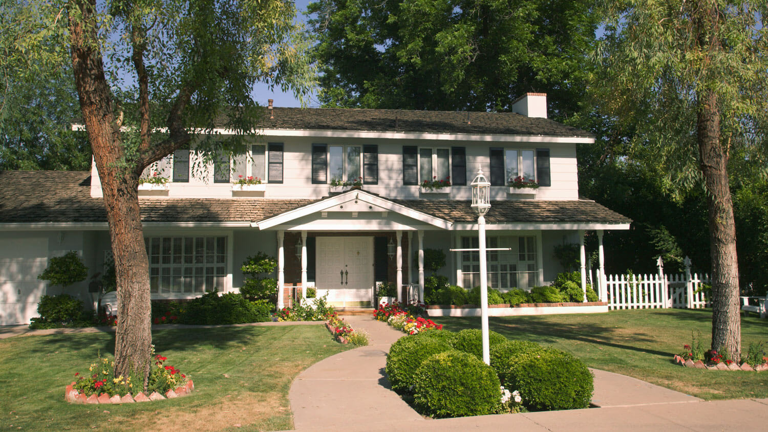 Two-story stucco house with concrete drive