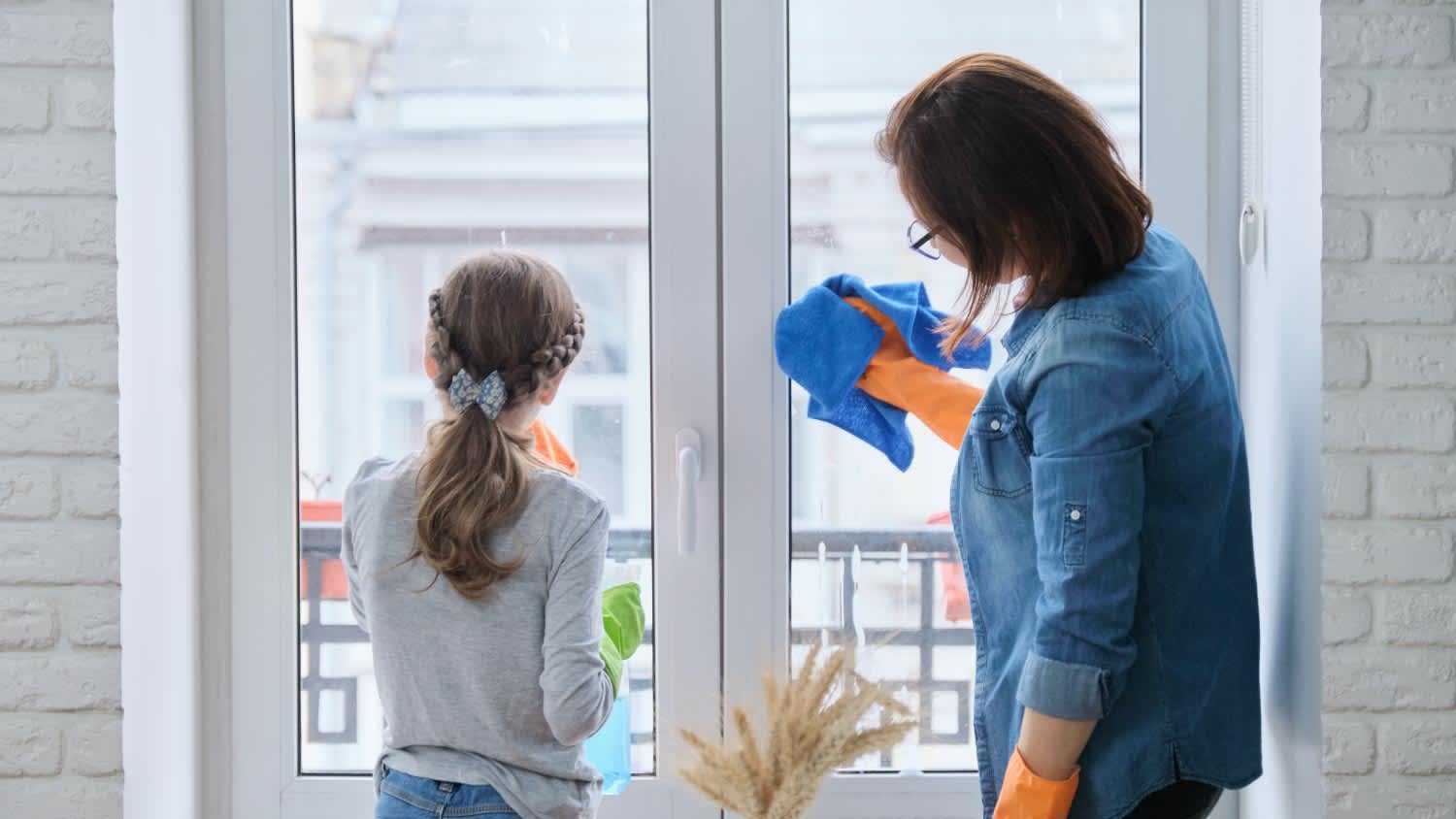 Mother and daughter cleaning windows together