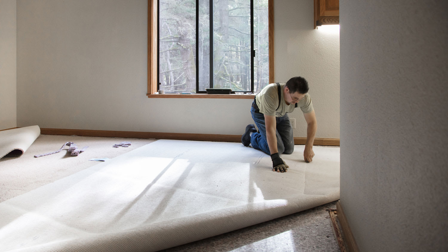 A professional installing a carpet padding on the floor