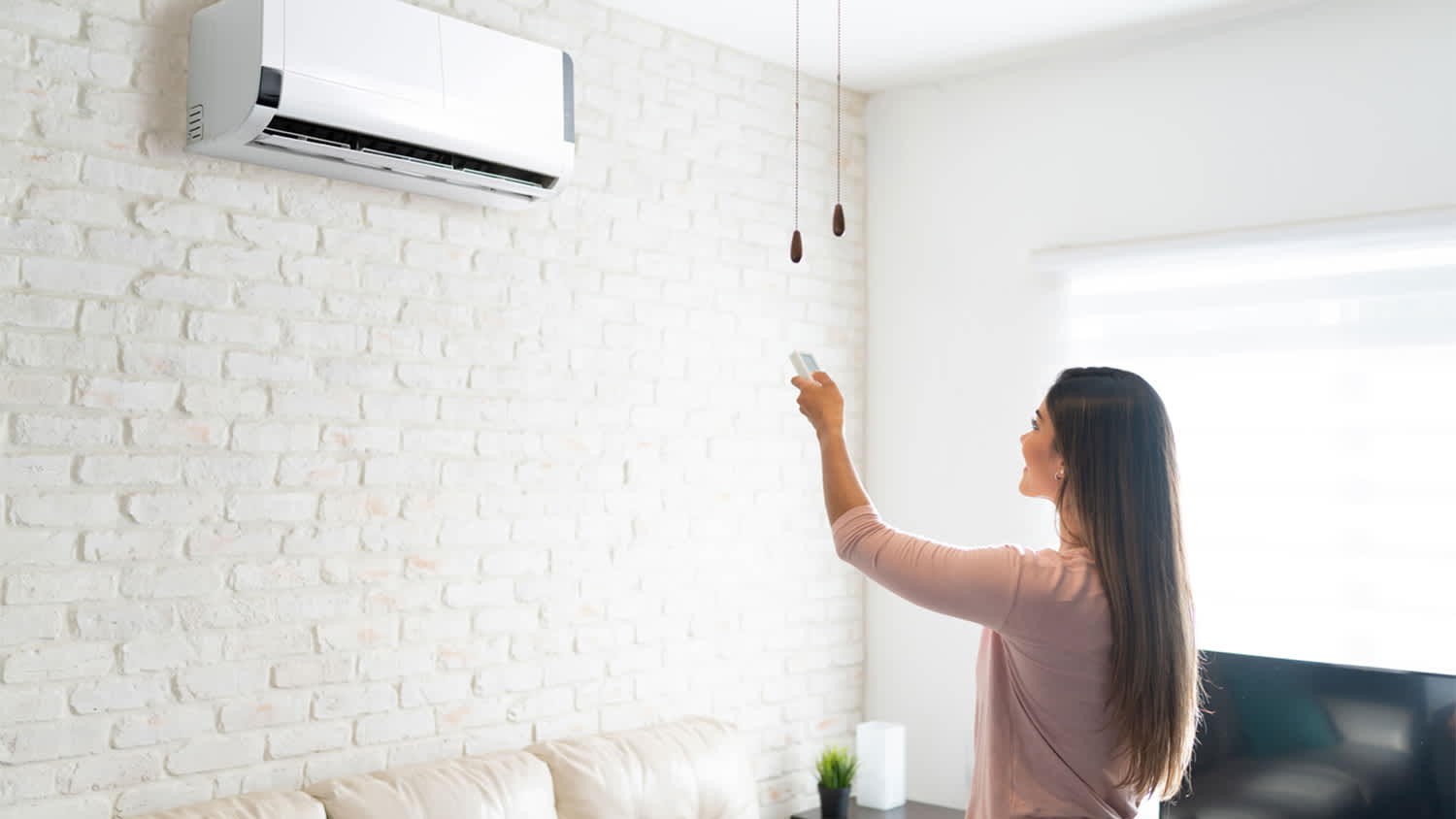 woman adjusting temperature with remote