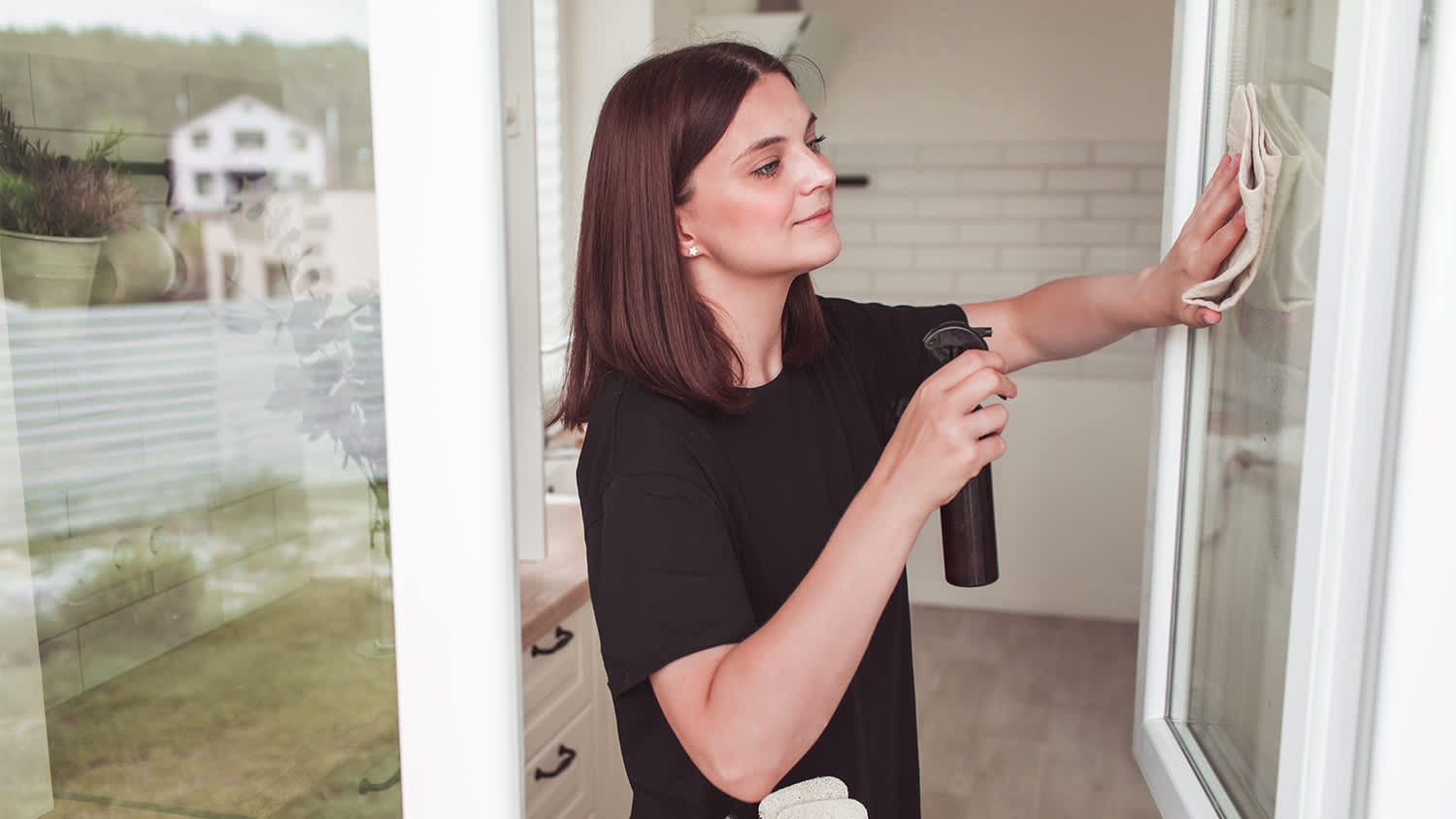 woman cleaning her windows with homemade cleaner