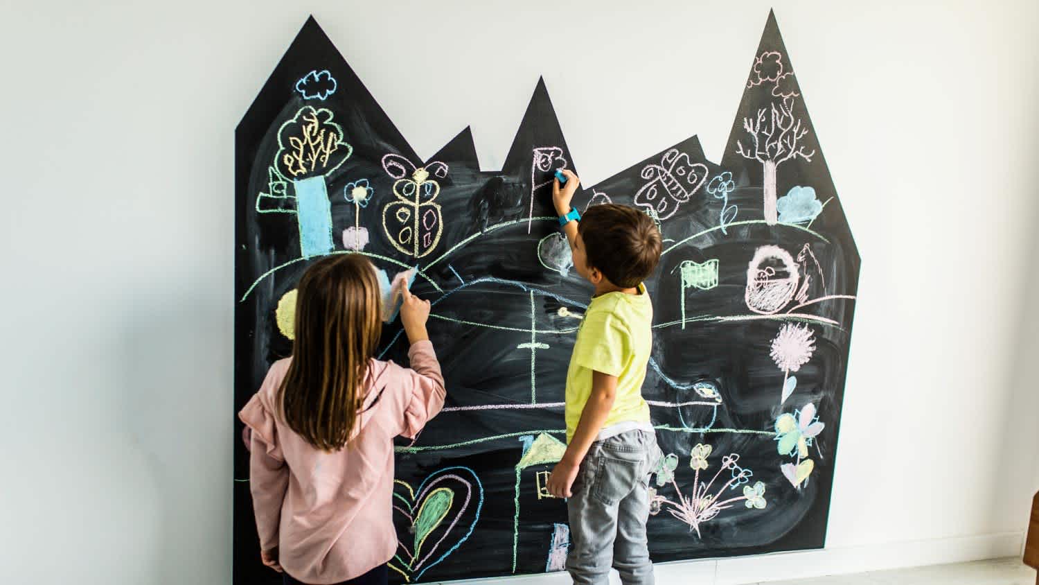 A brother and sister drawing on the blackboard