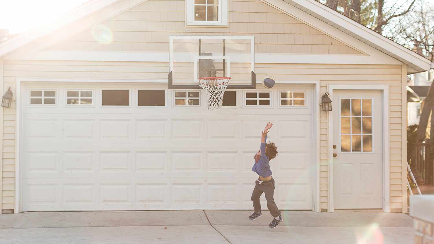 Kid playing outside garage door.