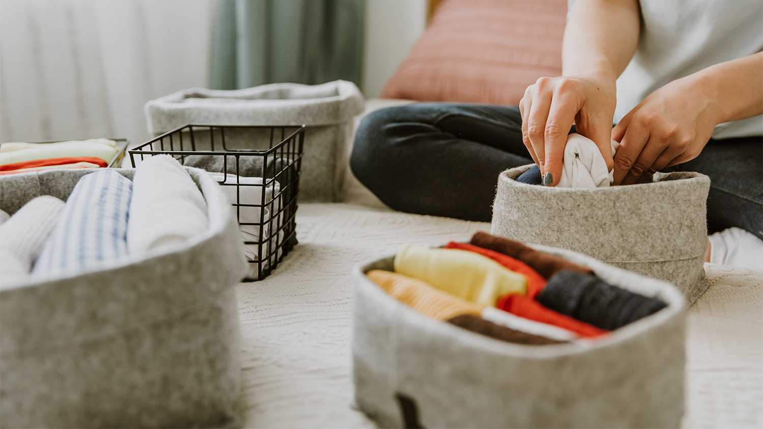 woman organizing clothes in small baskets